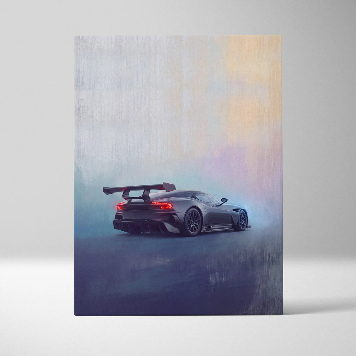 A sleek matte black aston martin vulcan inspired sports car with a rear wing and glowing red taillights on canvas art