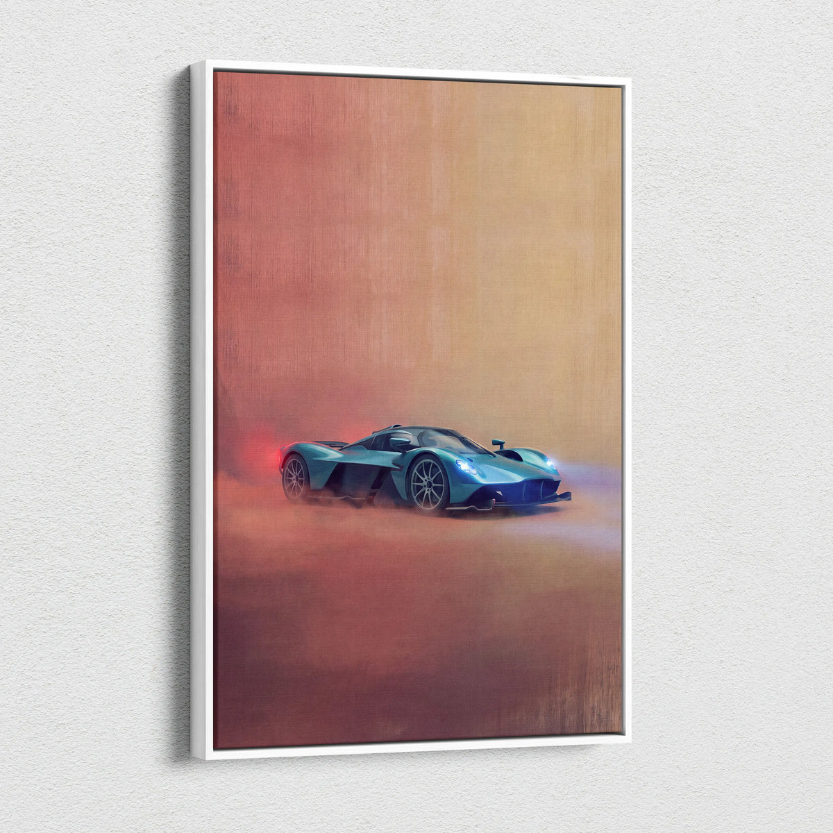 A framed canvas print of a turquoise Aston Martin Valkyrie sports car in motion on a warm red and orange gradient background