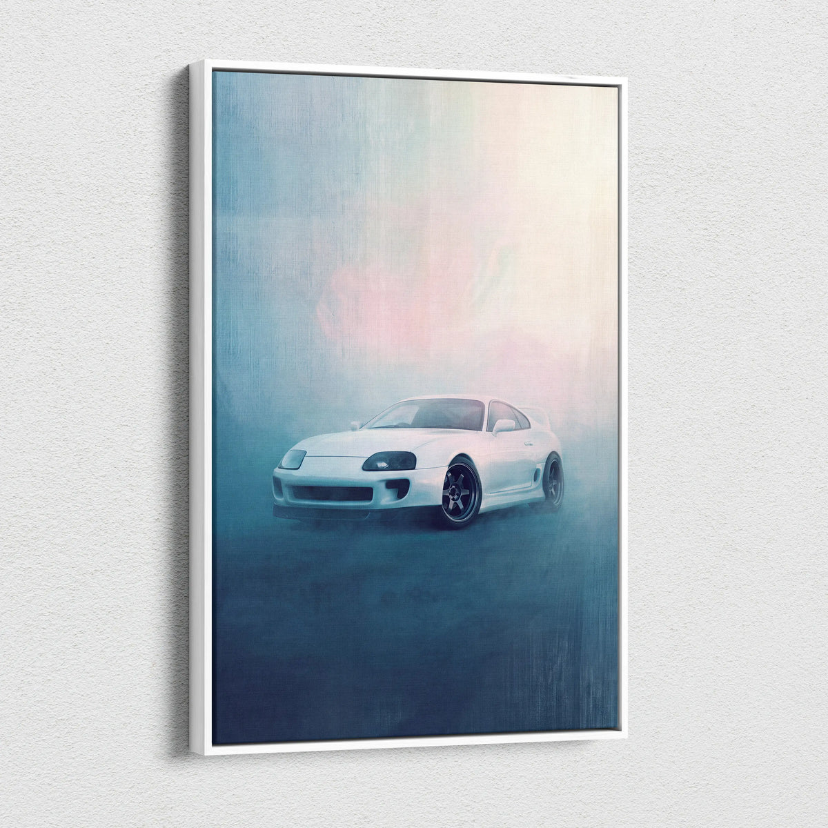 White framed canvas print featuring a sleek white Toyota Supra sports car in motion against a misty blue and pink background