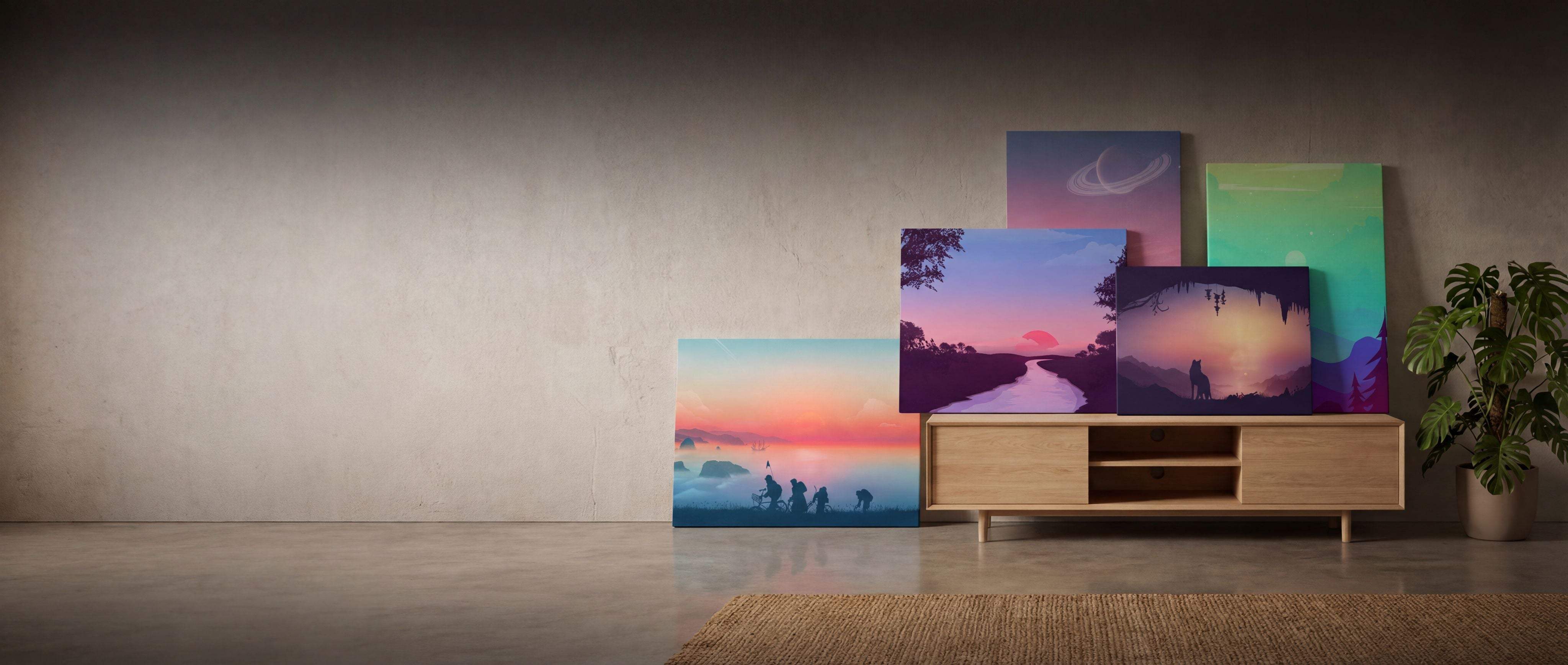 A set of five colorful canvas prints depicting serene sunset and landscape scenes, arranged on a wooden media console.
