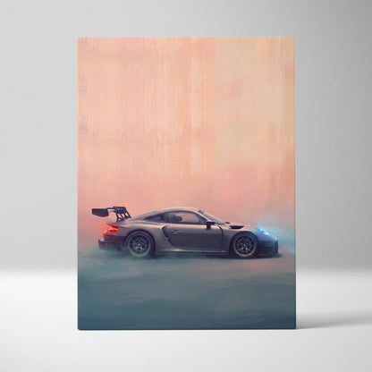 A sleek matte gray porsche 911 gt2 race car with a rear wing in motion on a peach to blue backdrop canvas print