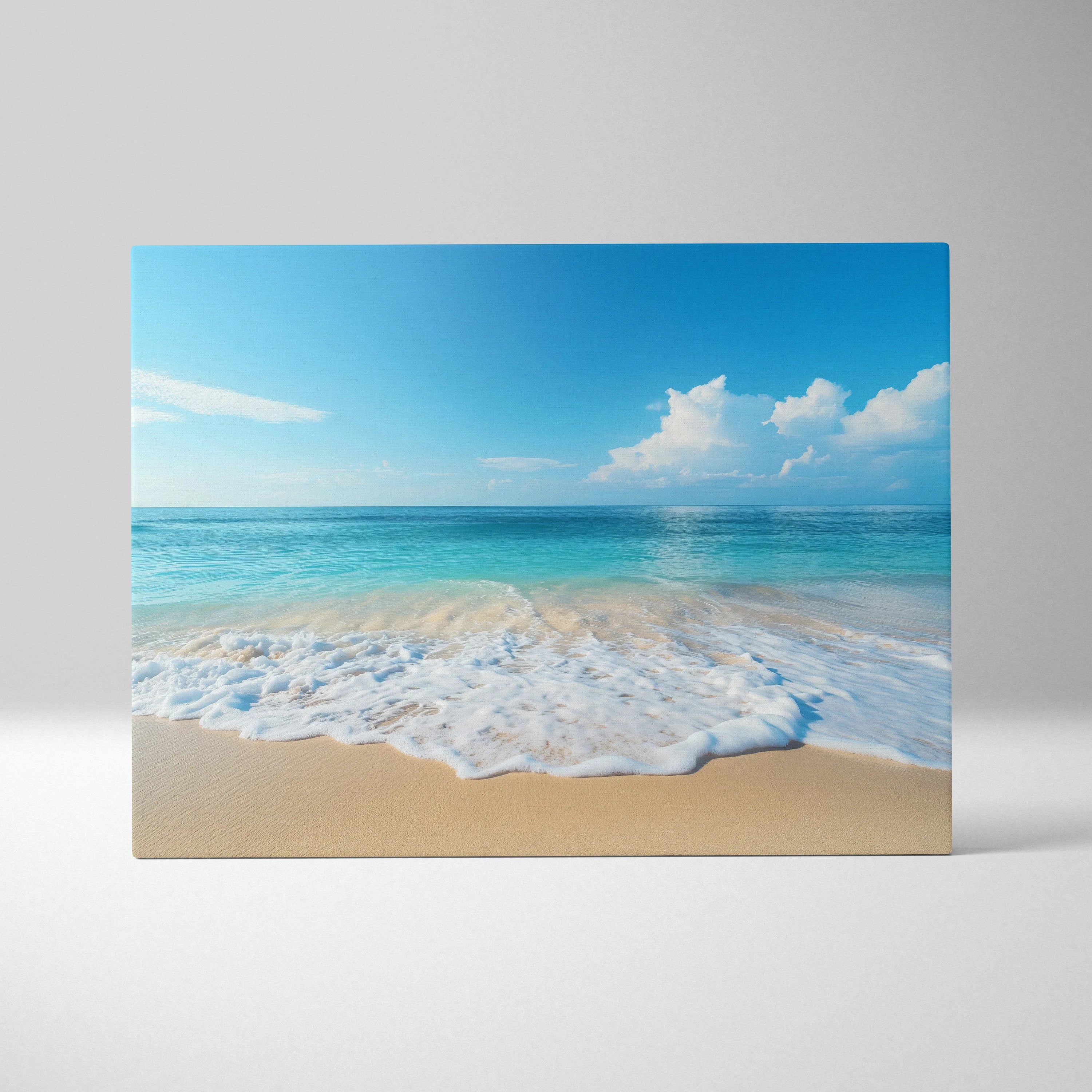 Canvas wall art featuring a serene beach scene with calm sandy waves and a bright blue sky with white clouds.