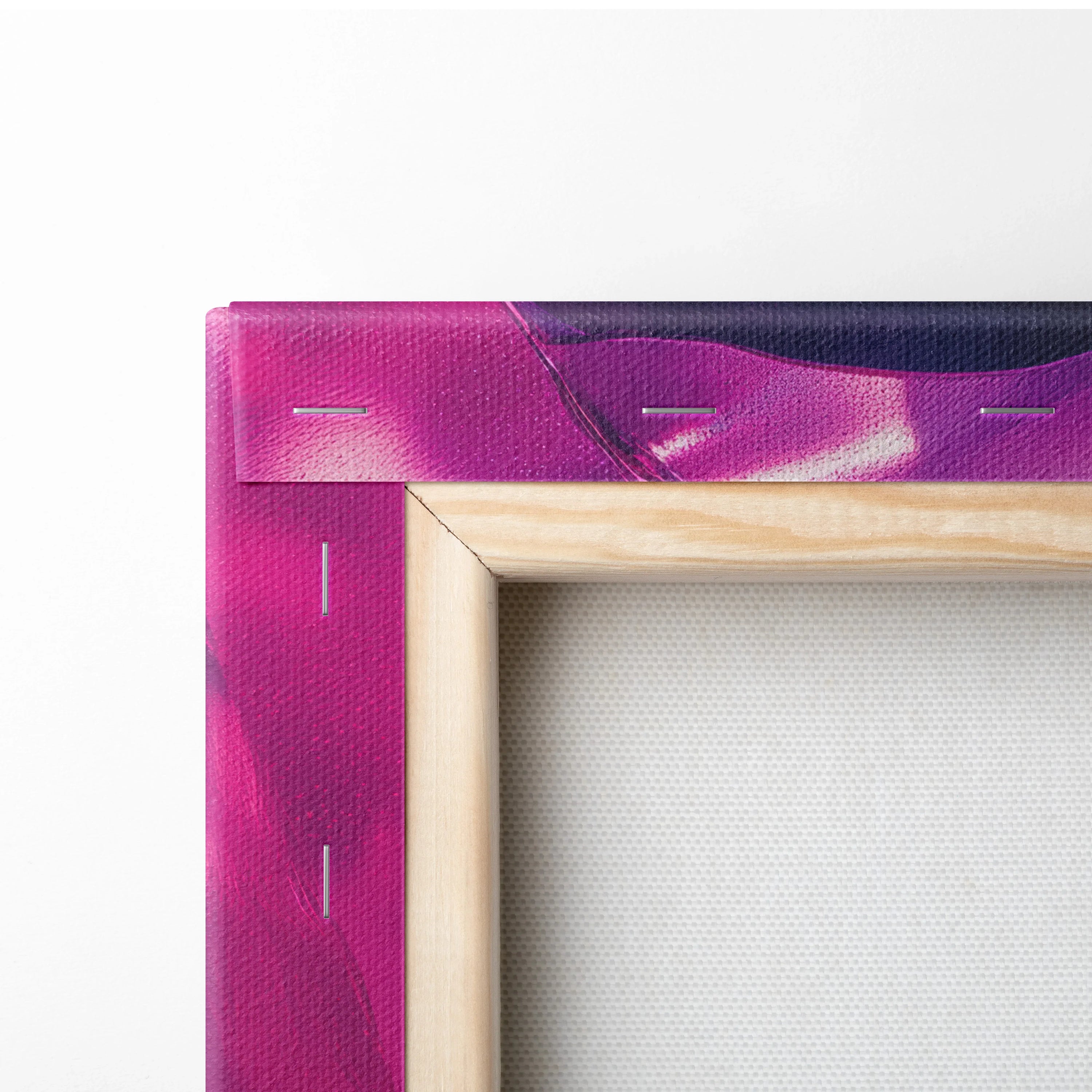 Close-up of wooden frame corner with stretched vibrant purple and pink abstract canvas art.