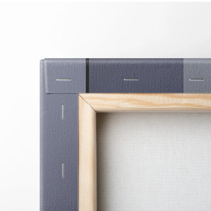 Close-up of a minimalist canvas wall art corner with a natural wood frame and textured gray fabric backing.