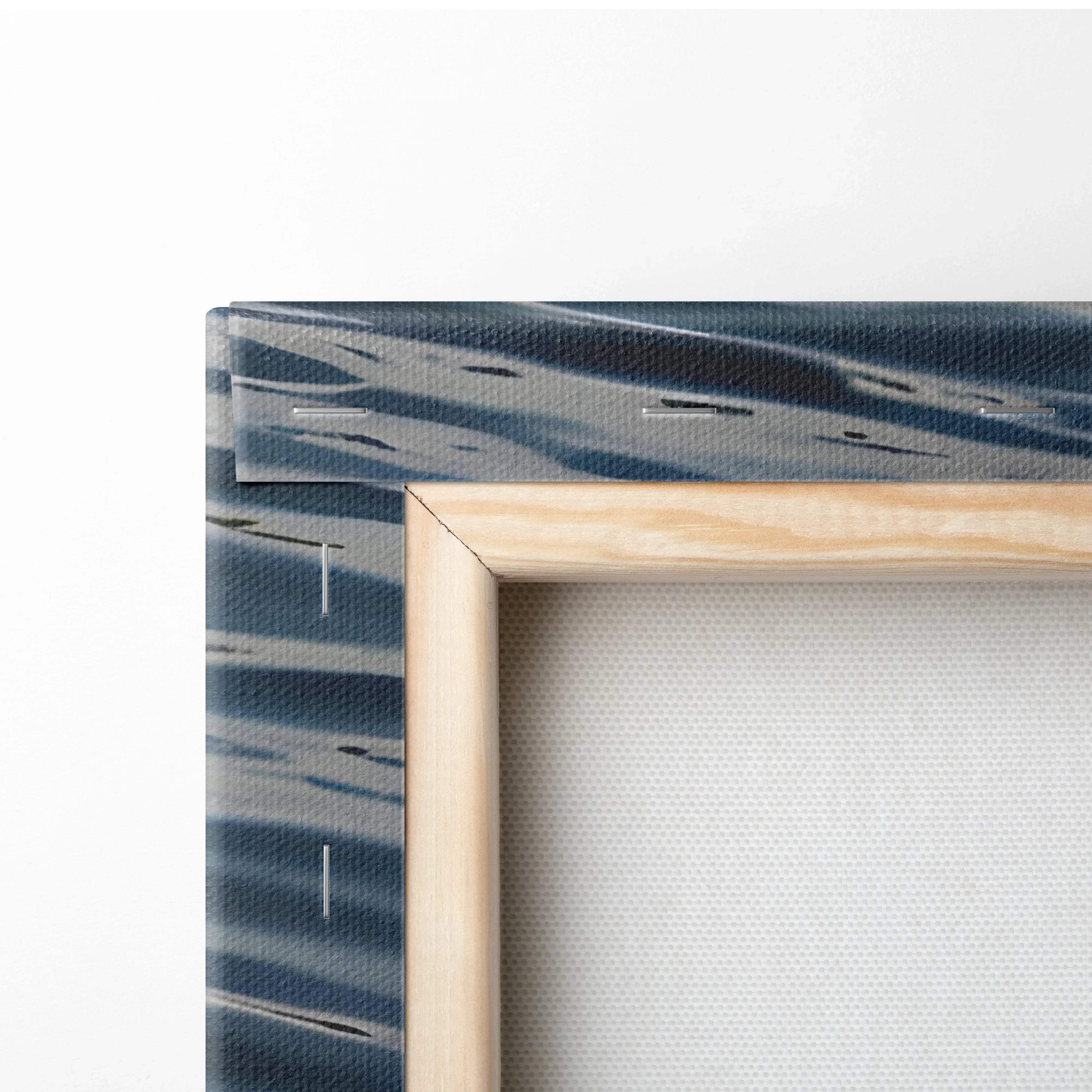 Light-colored wooden frame holding a canvas with abstract blue and gray brushstroke watercolor ocean seascape wall art