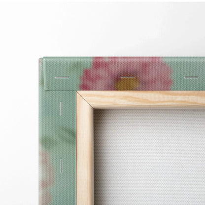 Close-up of wooden frame corner on floral canvas wall art with green and pink tones.