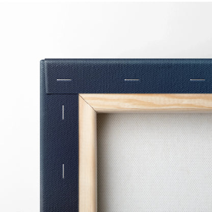 Corner close-up of canvas wall art showing natural wood frame and navy blue wrapped edges.