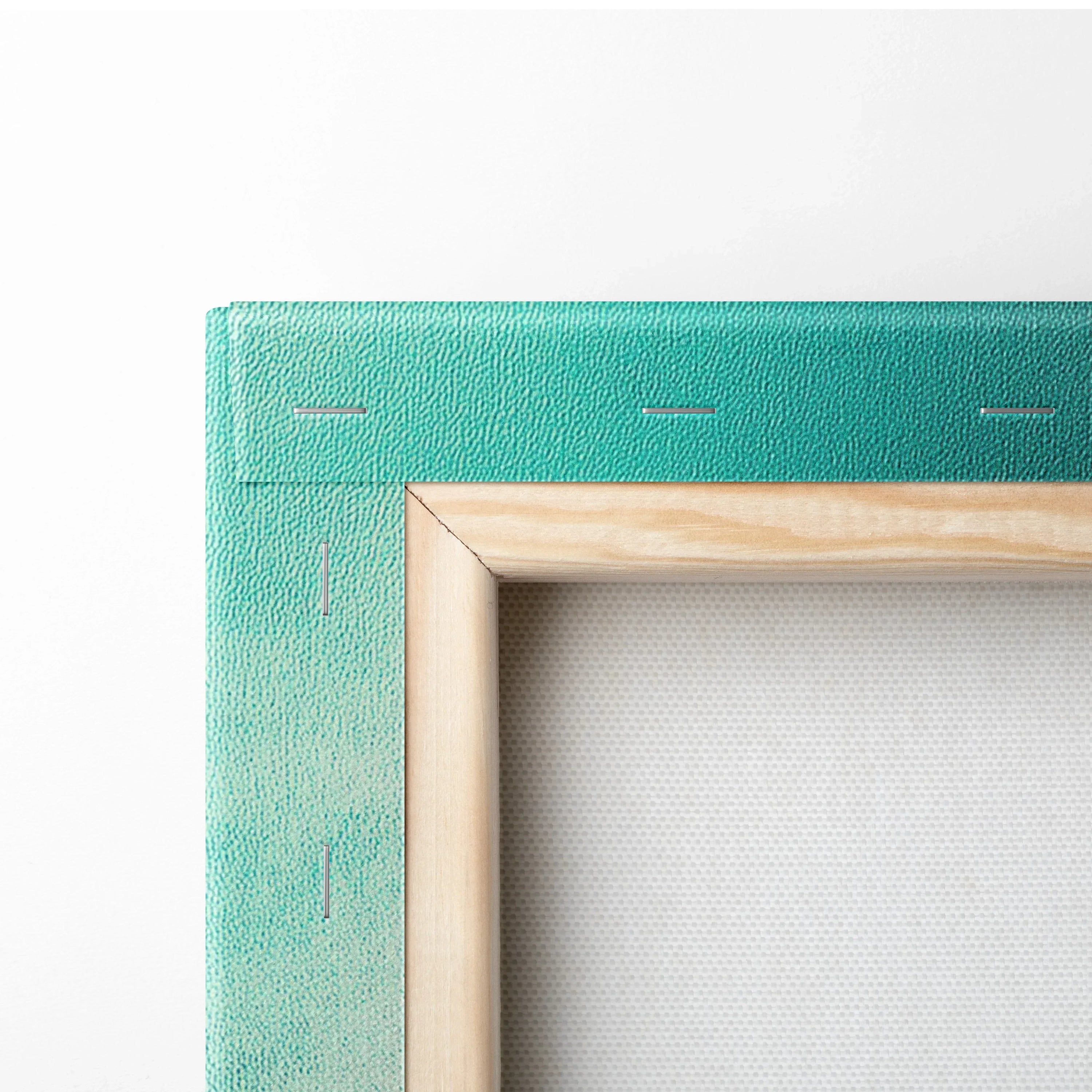 Close-up of teal canvas stretched over wooden frame with visible staples on wall art edge.