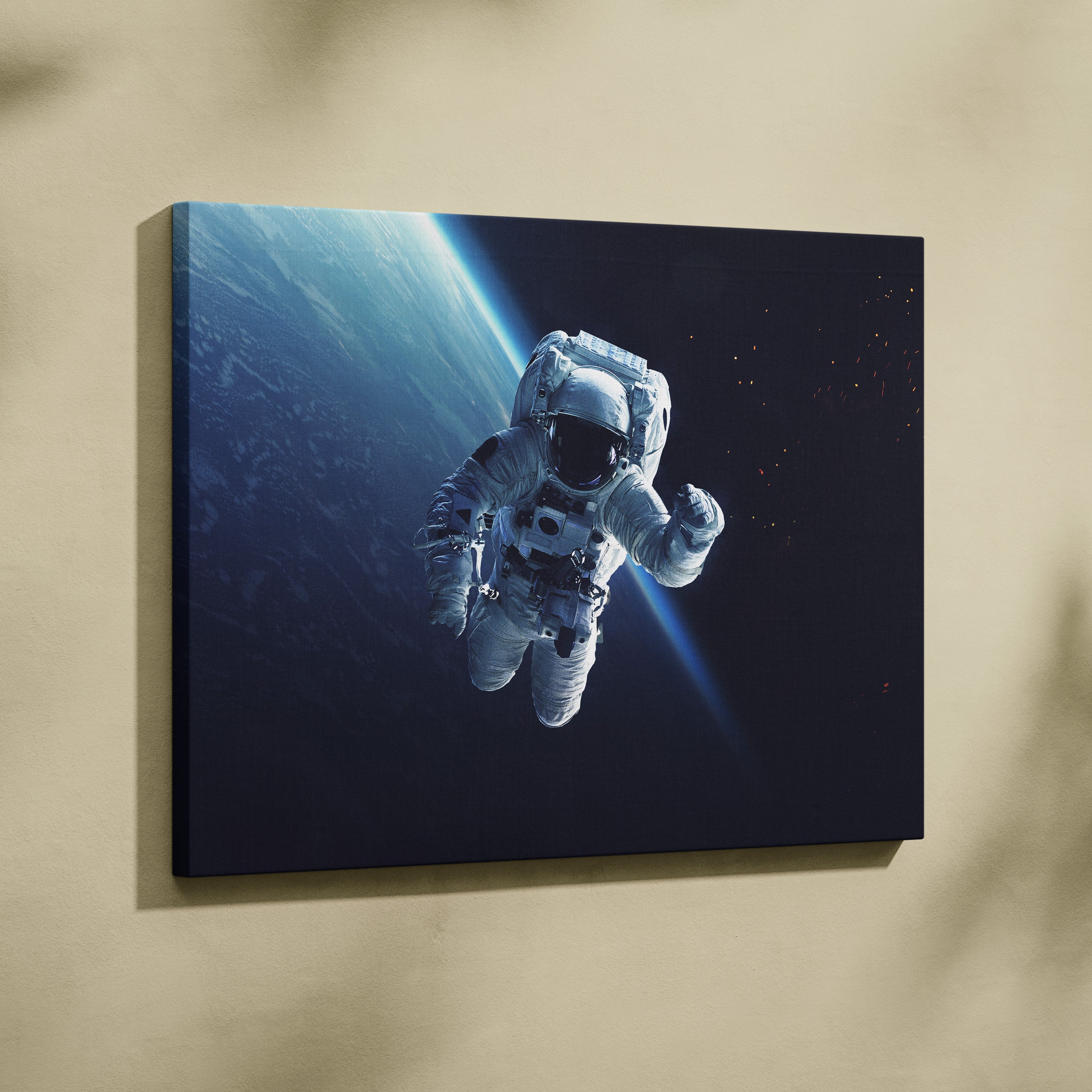 A sleek framed canvas print of a white astronaut floating in space with earths curved blue horizon backdrop