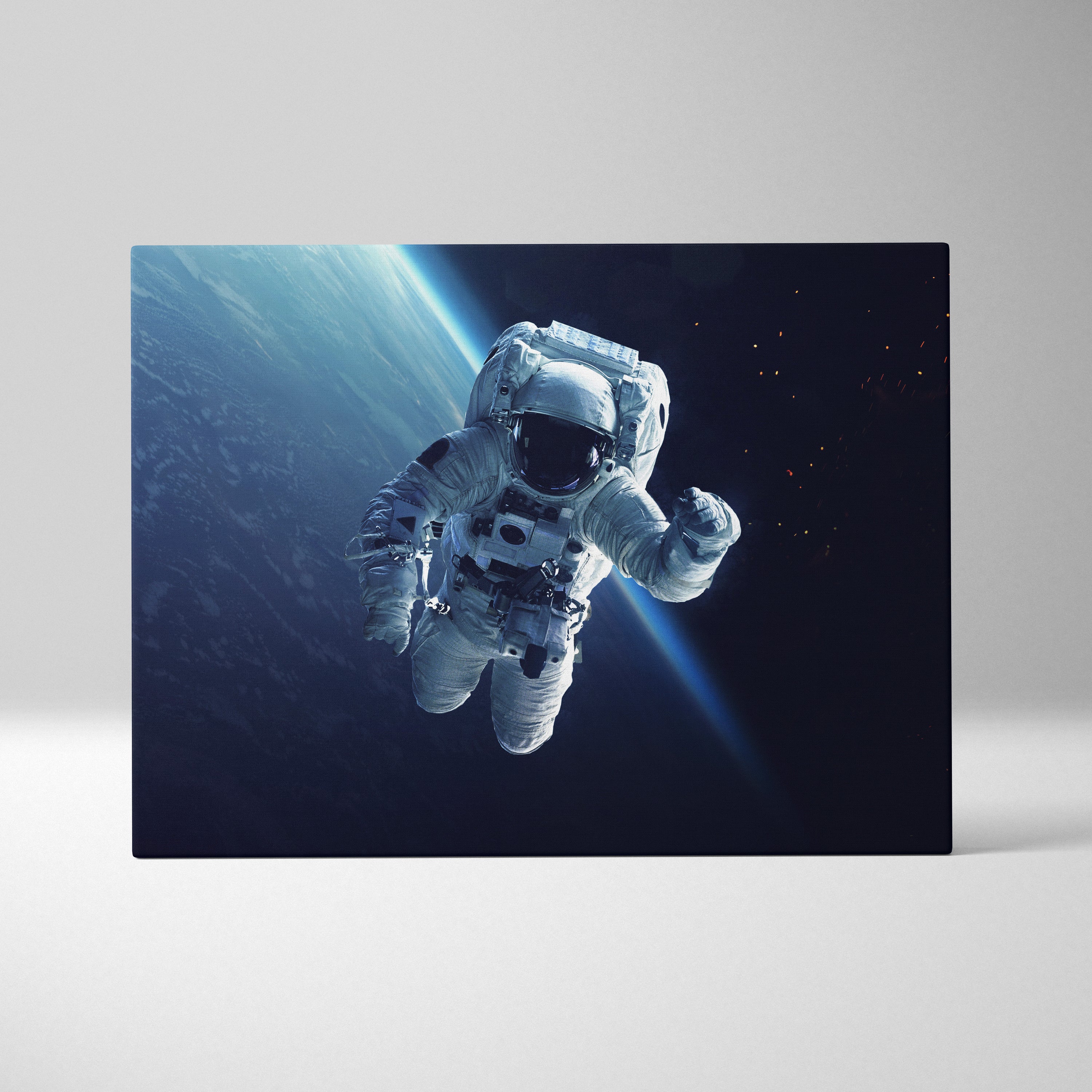 White astronaut in space canvas wall art print showing blue earth orbit against starry backdrop for modern decor