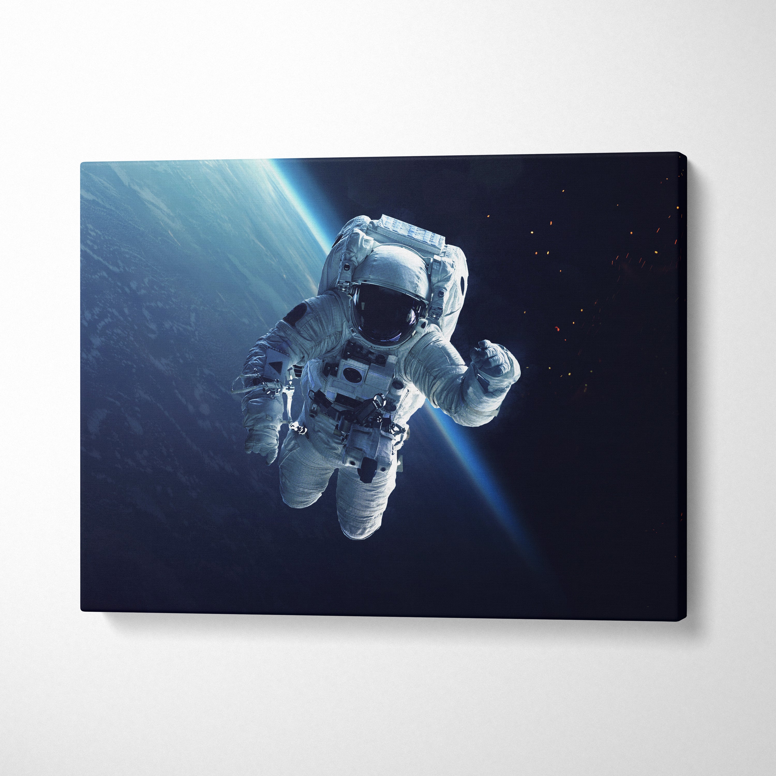 Astronaut in space canvas wall art print showing a white suited astronaut floating with blue light rays in earth orbit