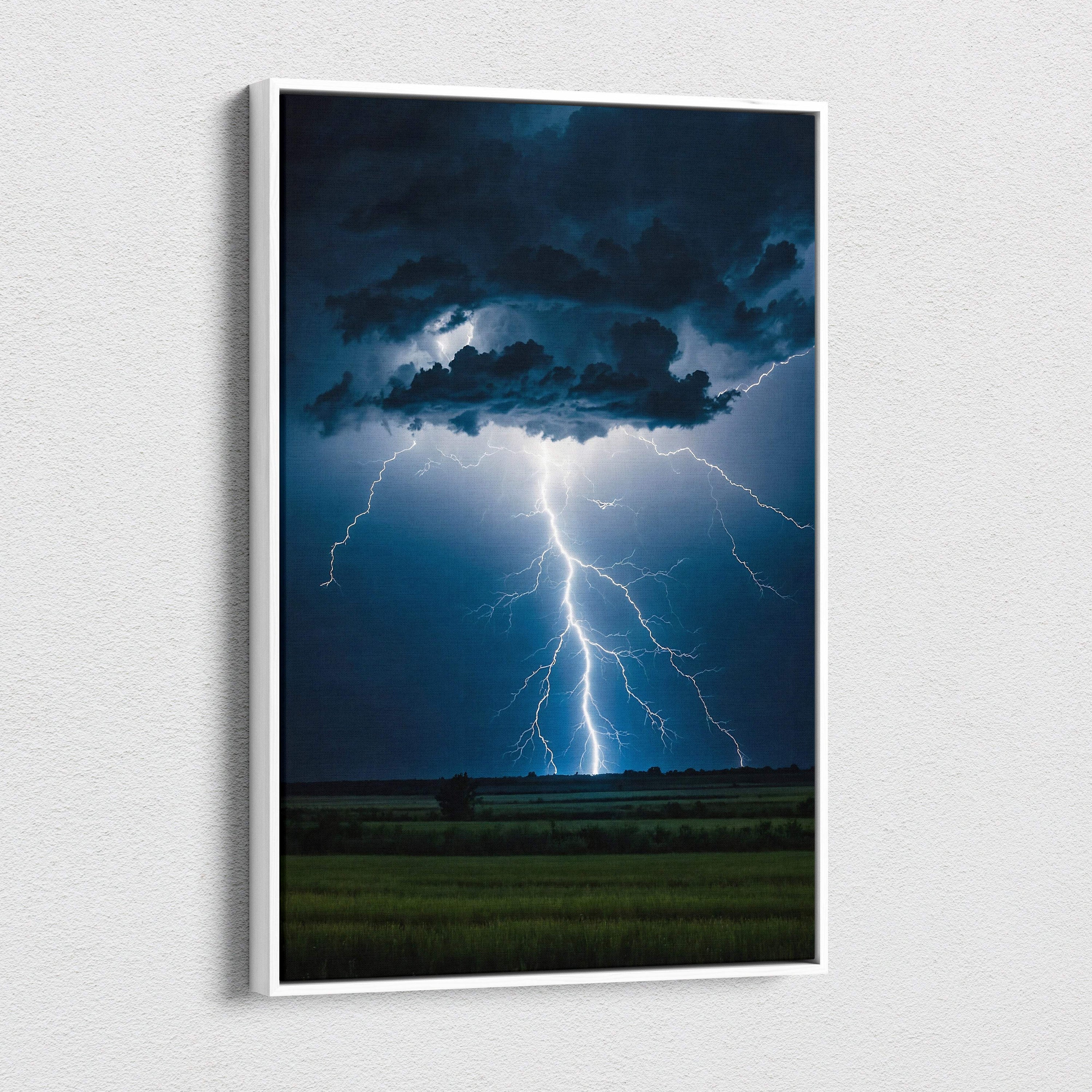 A framed canvas print of a powerful blue and white cloud-to-ground lightning strike over a dark stormy field at night