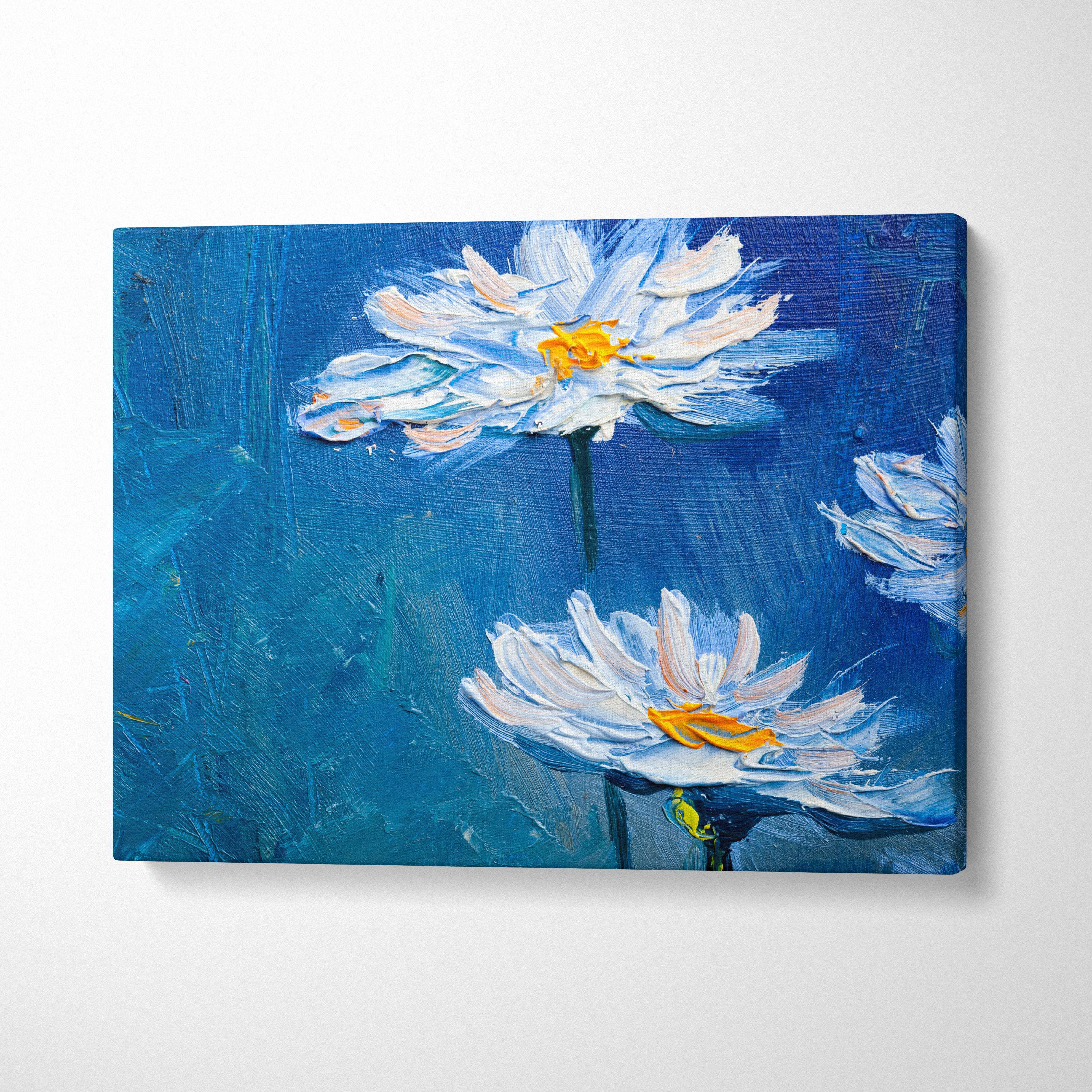 Blue canvas wall art featuring white daisies with yellow centers in thick impasto brushstrokes modern floral print