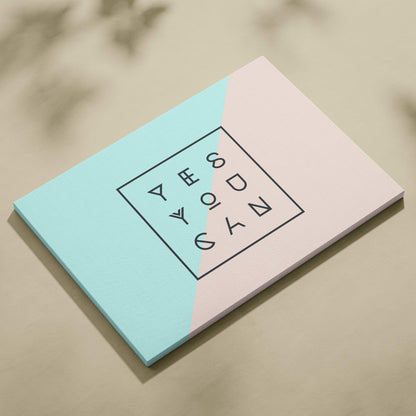 Minimalist notebook with pastel blue and pink geometric design featuring yeezy text in black outlined letters in a square frame
