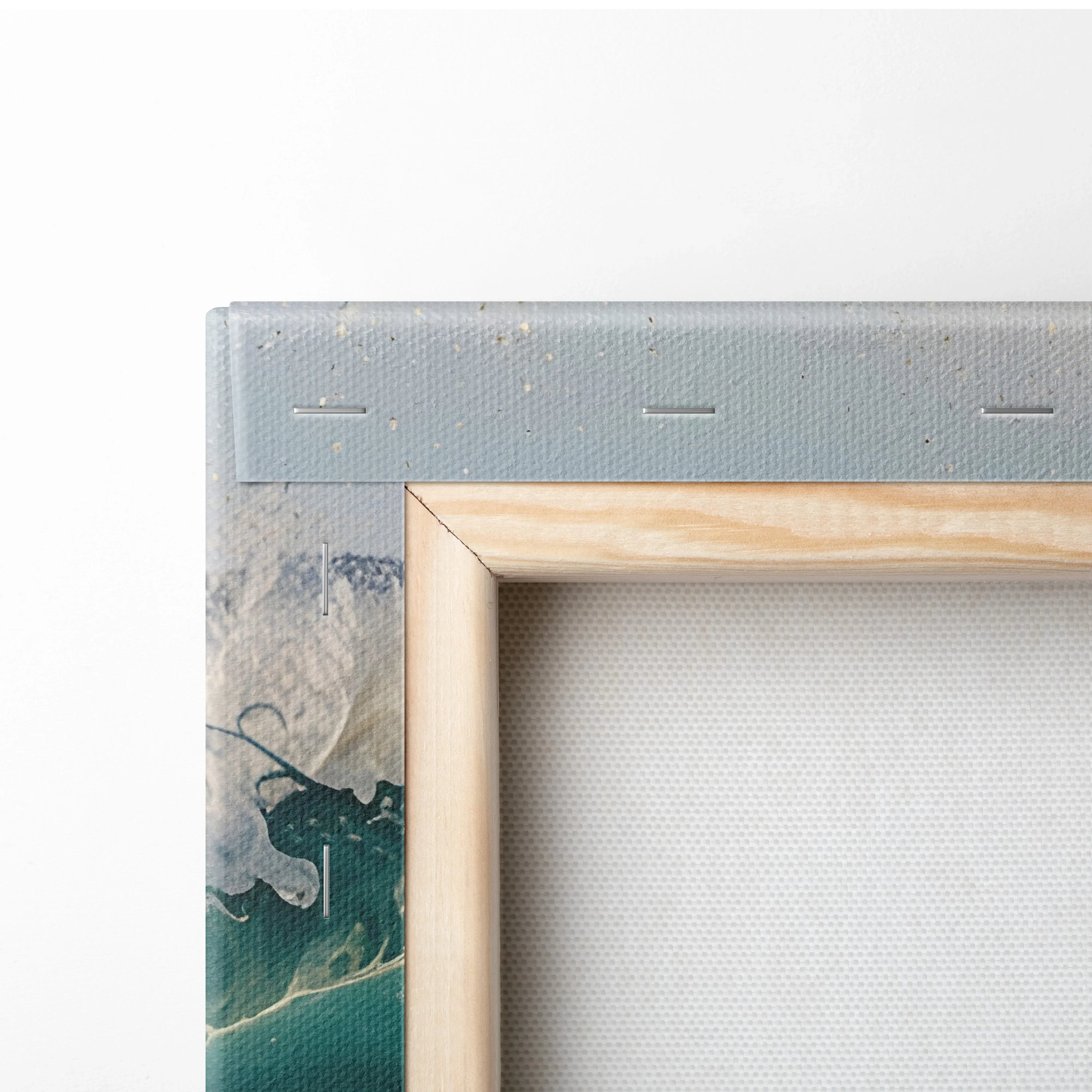Corner close-up of watercolor ocean seascape art on canvas with wooden frame and staples on back wall art.