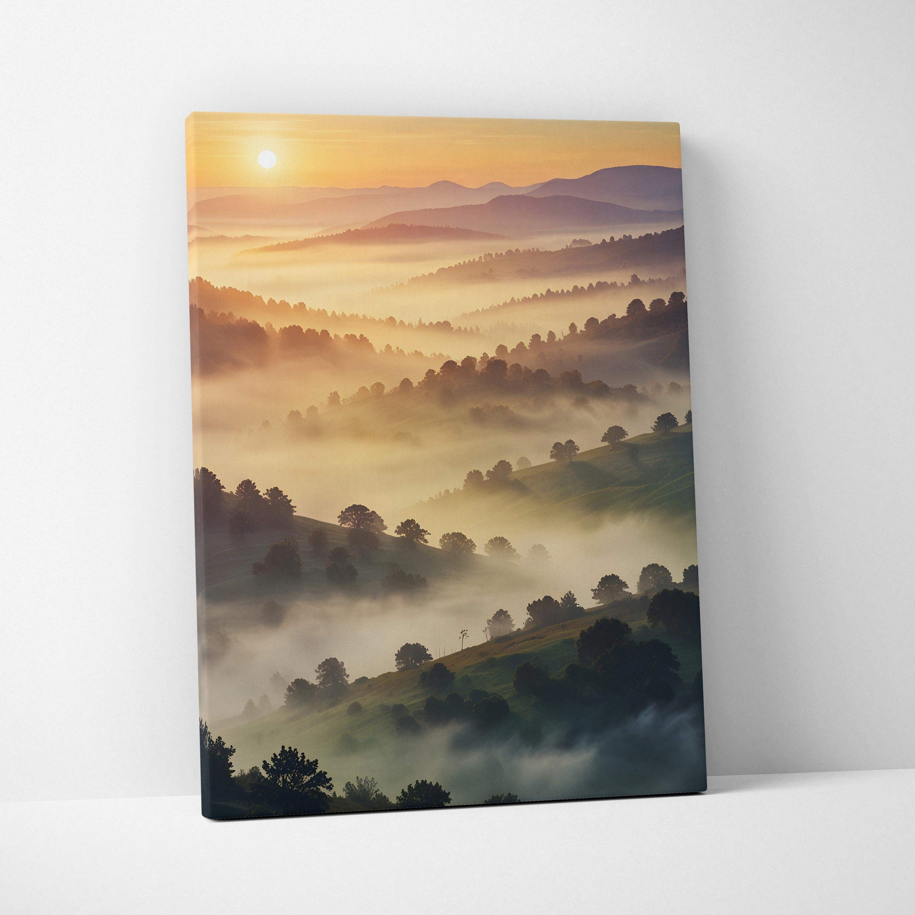 Canvas wall art featuring a vivid sunset over misty forested hills in warm watercolor tones.