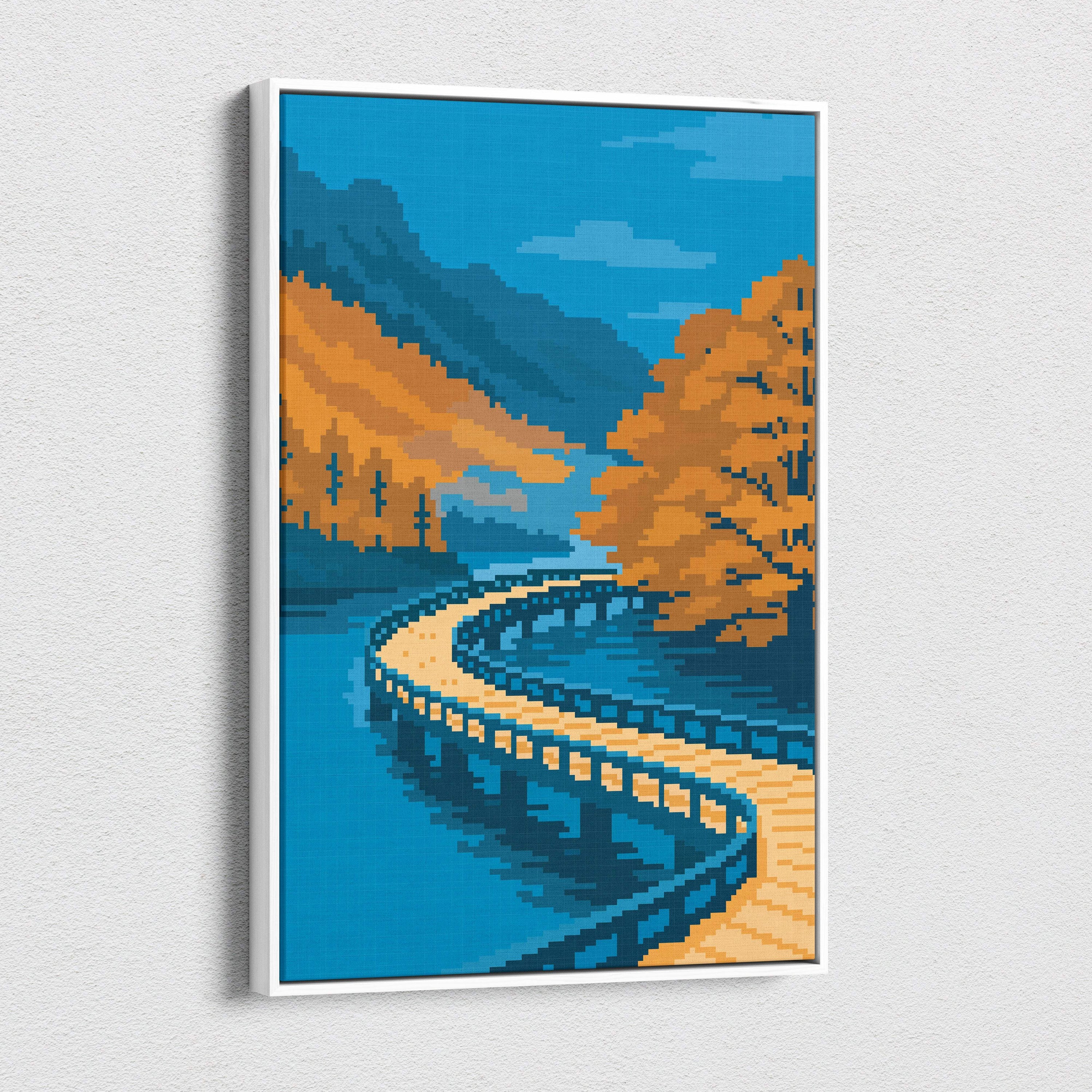 A framed pixel art canvas print of a winding wooden bridge over turquoise water with autumnal trees and blue mountains