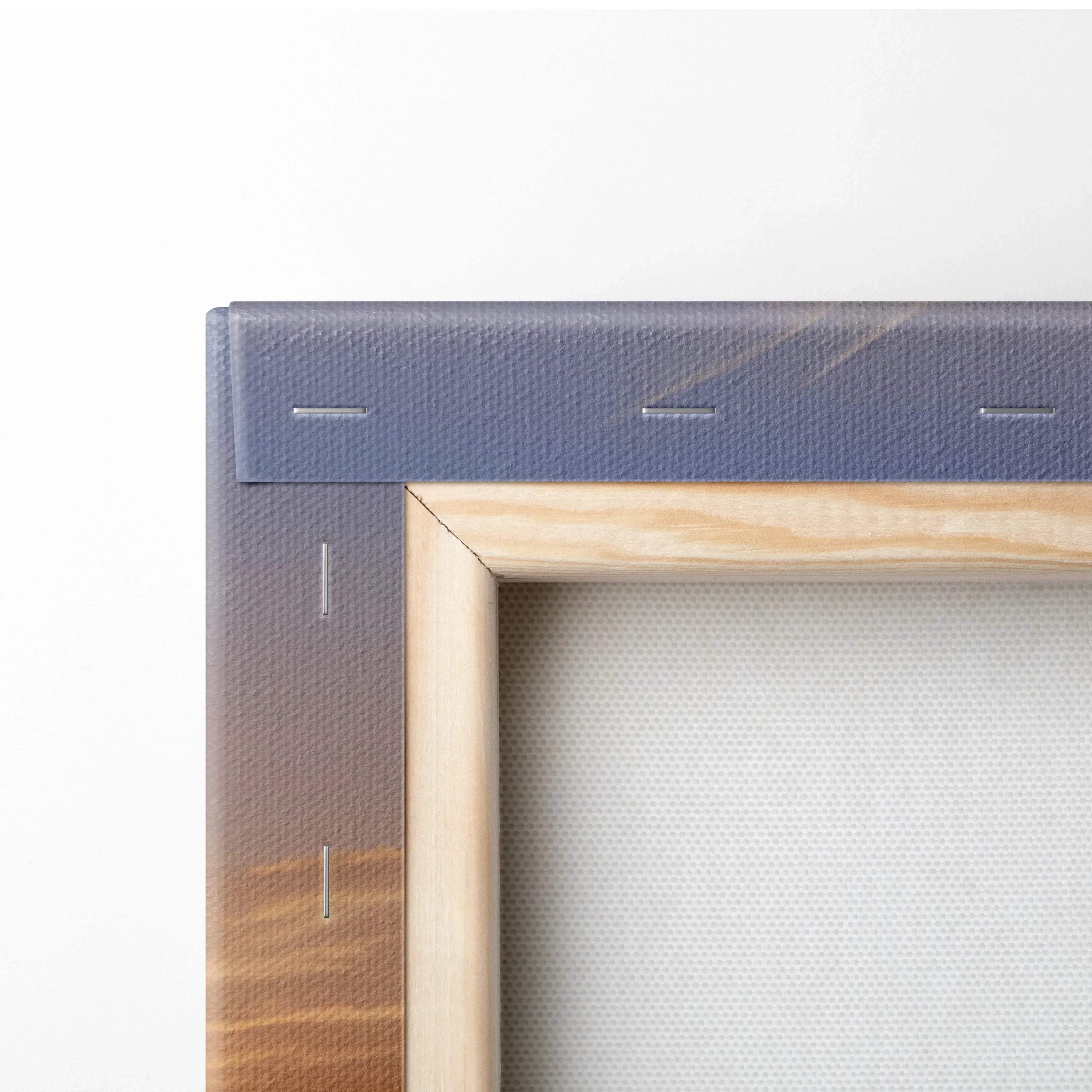 Close-up of stretched canvas wall art with wooden frame showcasing vibrant sunset floral design edges.