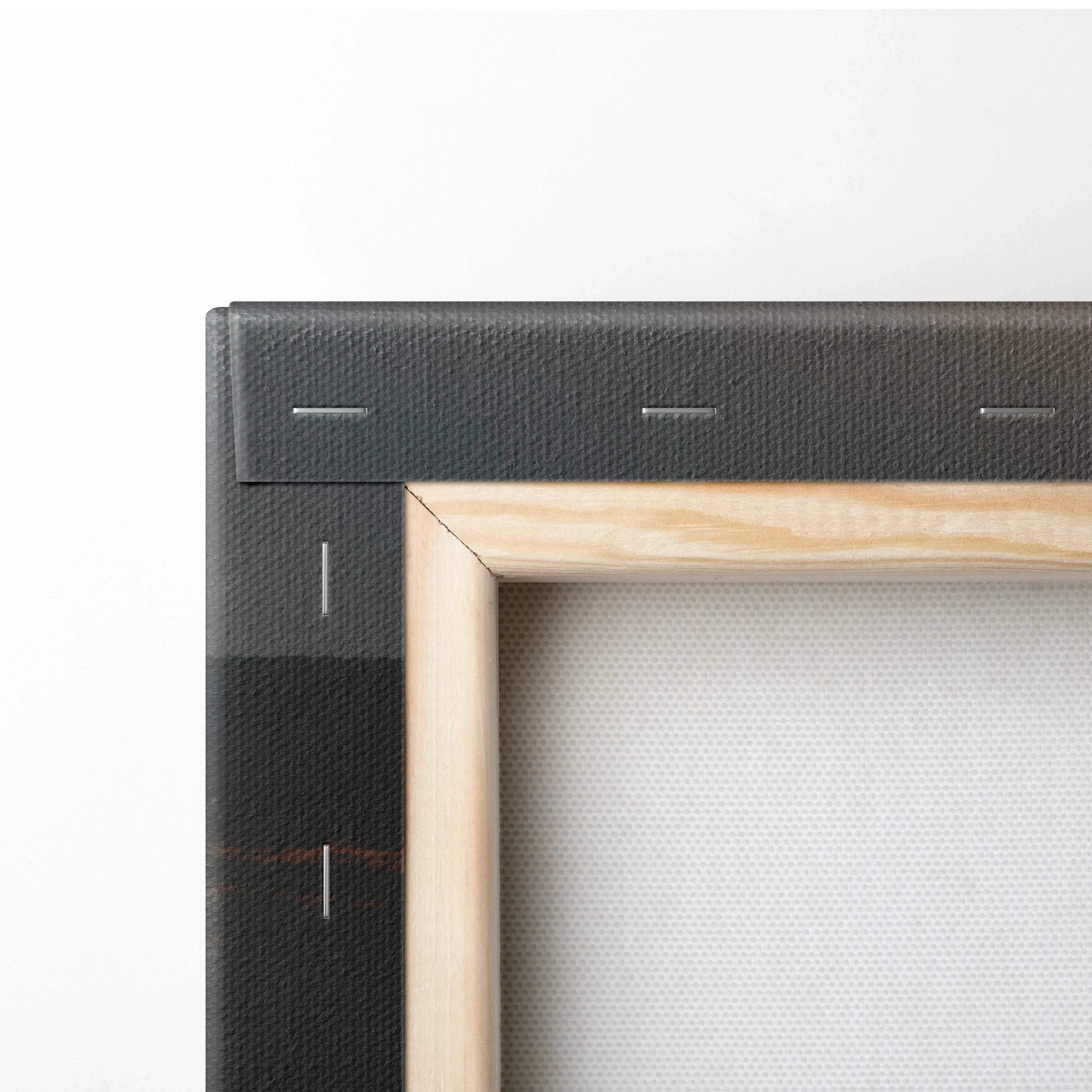 Close-up of natural wood frame corner on stretched canvas wall art with visible canvas texture and black stapled stretcher.