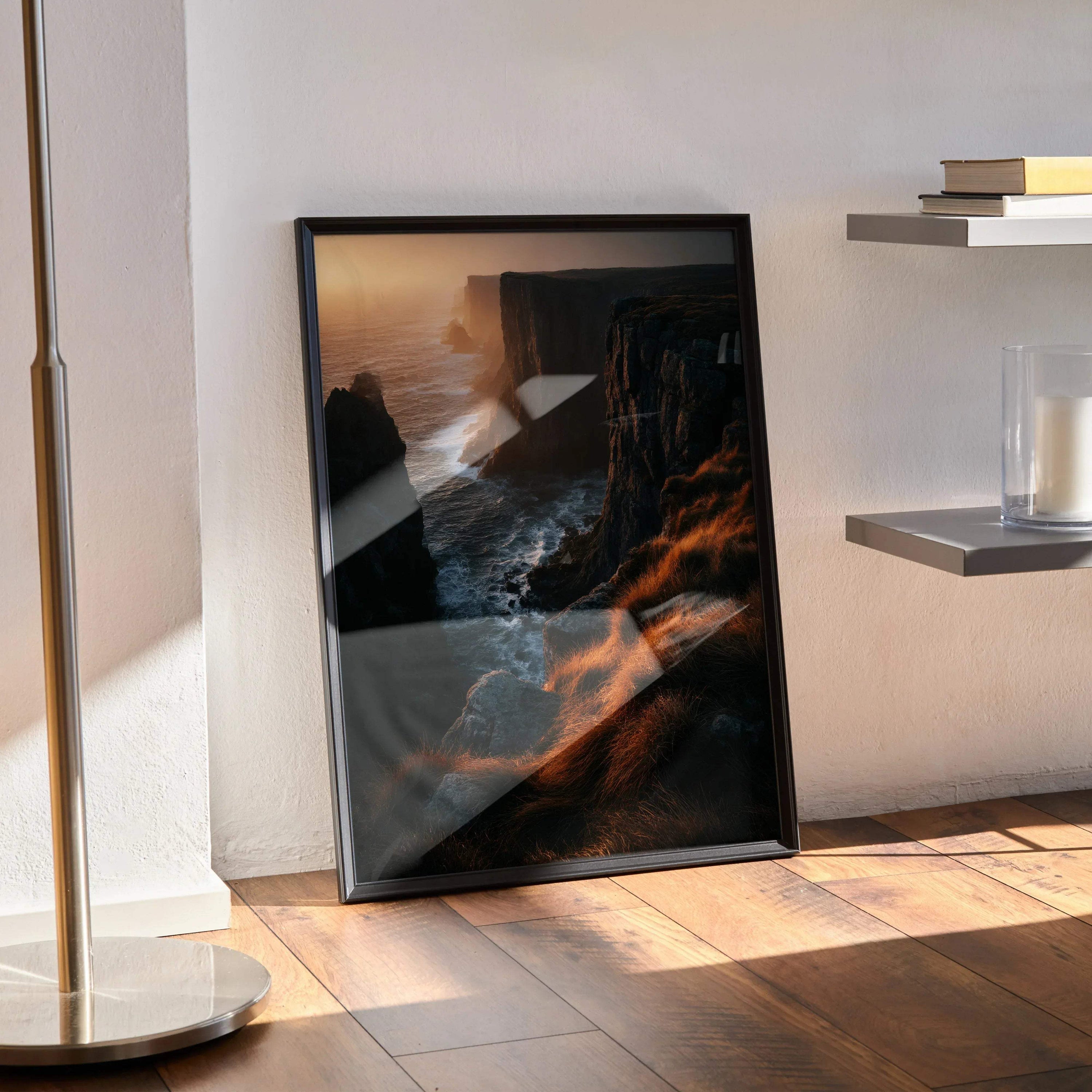Framed vertical sunset nature poster featuring rugged cliffs and glowing ocean waves, moody wall art.