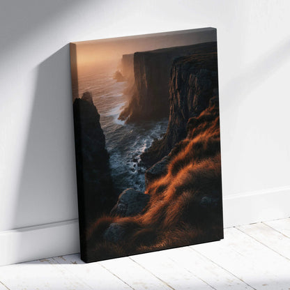 Canvas wall art featuring a dramatic sunset over rugged cliffs with glowing orange grasses and dark ocean waves.