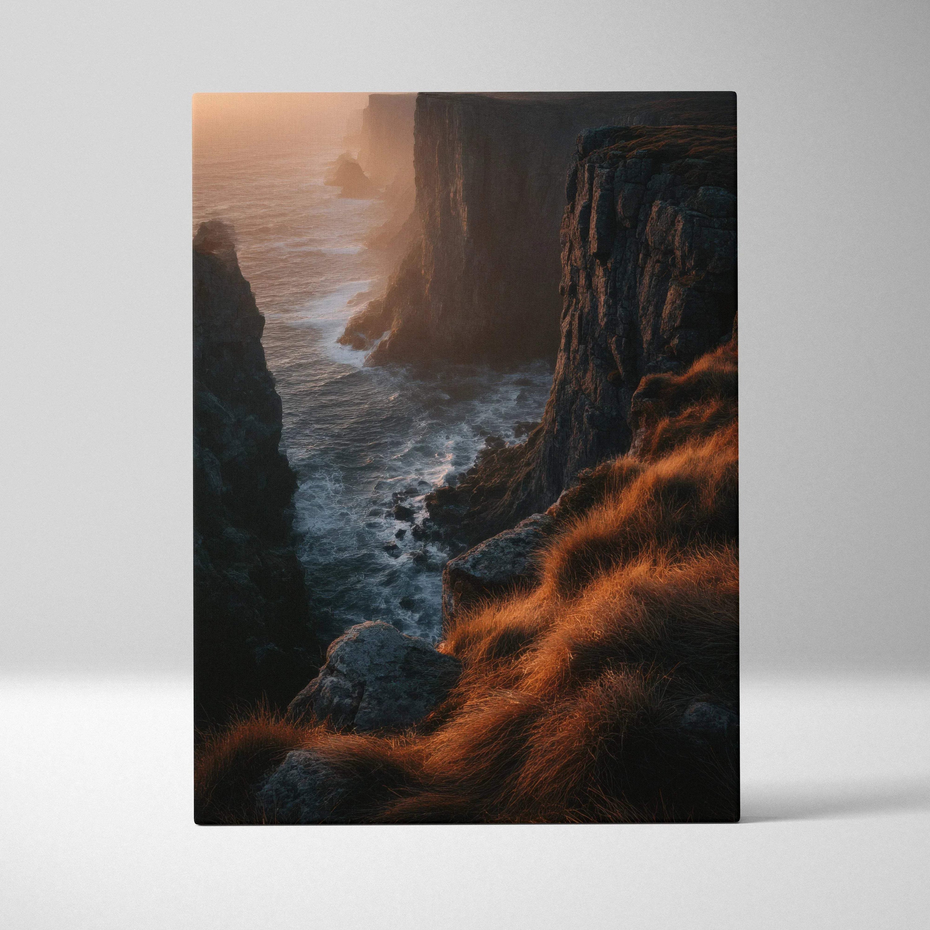 Vertical canvas wall art featuring a dramatic sunset over rocky cliffs and ocean waves with golden grassy foreground.
