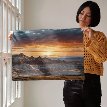 Watercolor poster wall art of vibrant sunset behind mountain range with clouds and soft light.