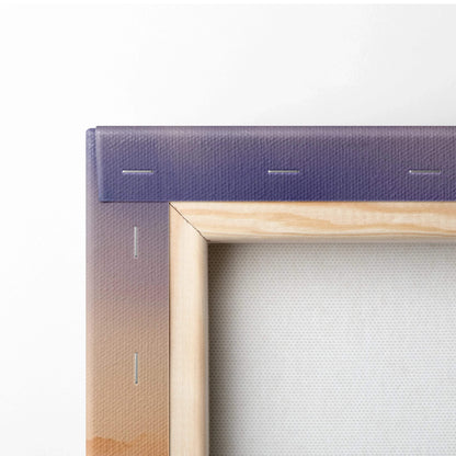Close-up of canvas edge showing vibrant purple and orange watercolor mountain print on wooden frame wall art.
