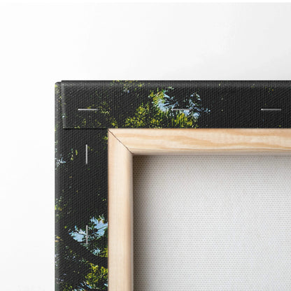 Close-up of black canvas wall art corner with visible wood stretcher bar and green foliage design.