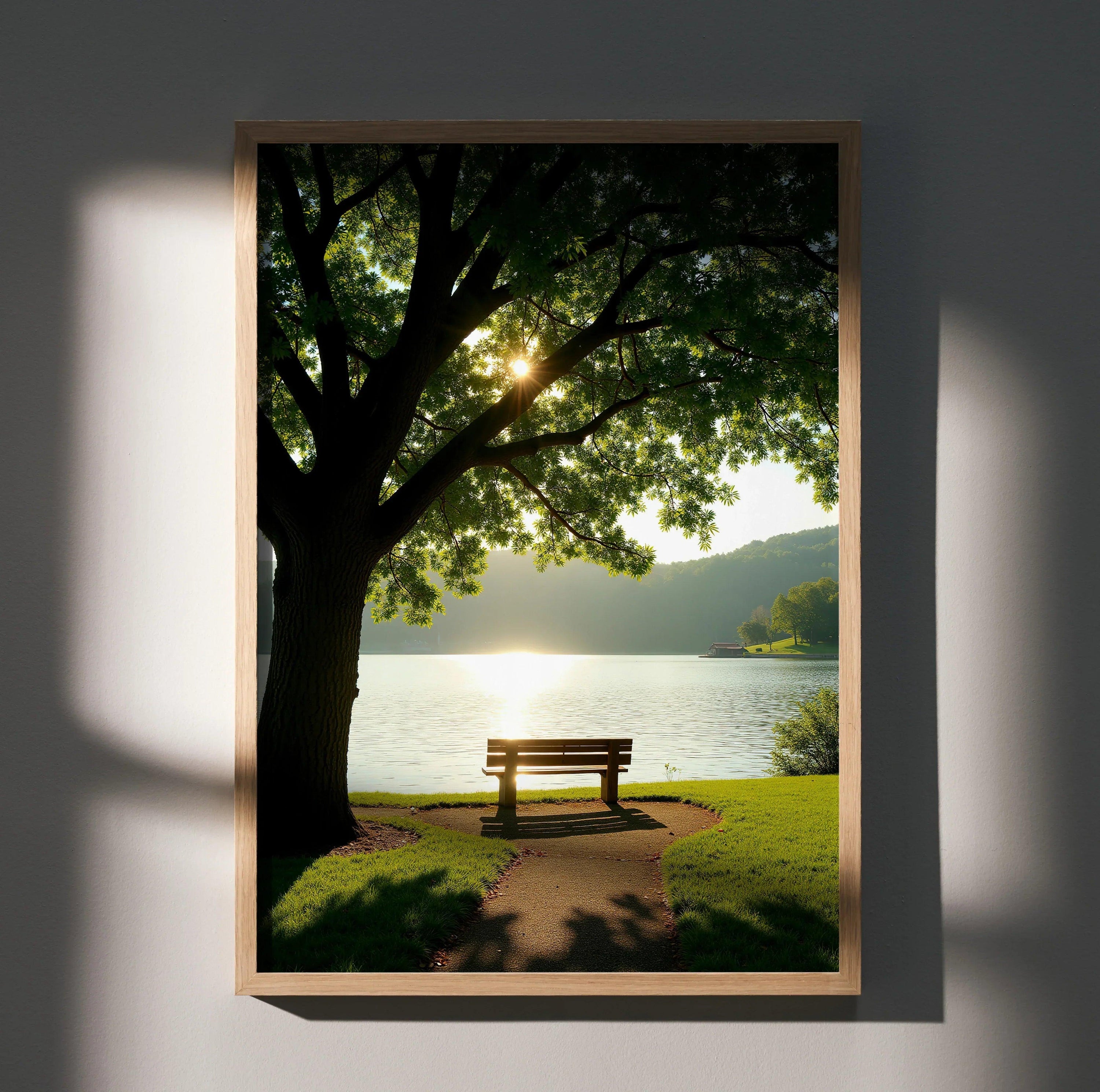Vertical wall art poster showing a sunlit bench by a lake under a leafy tree at sunset.
