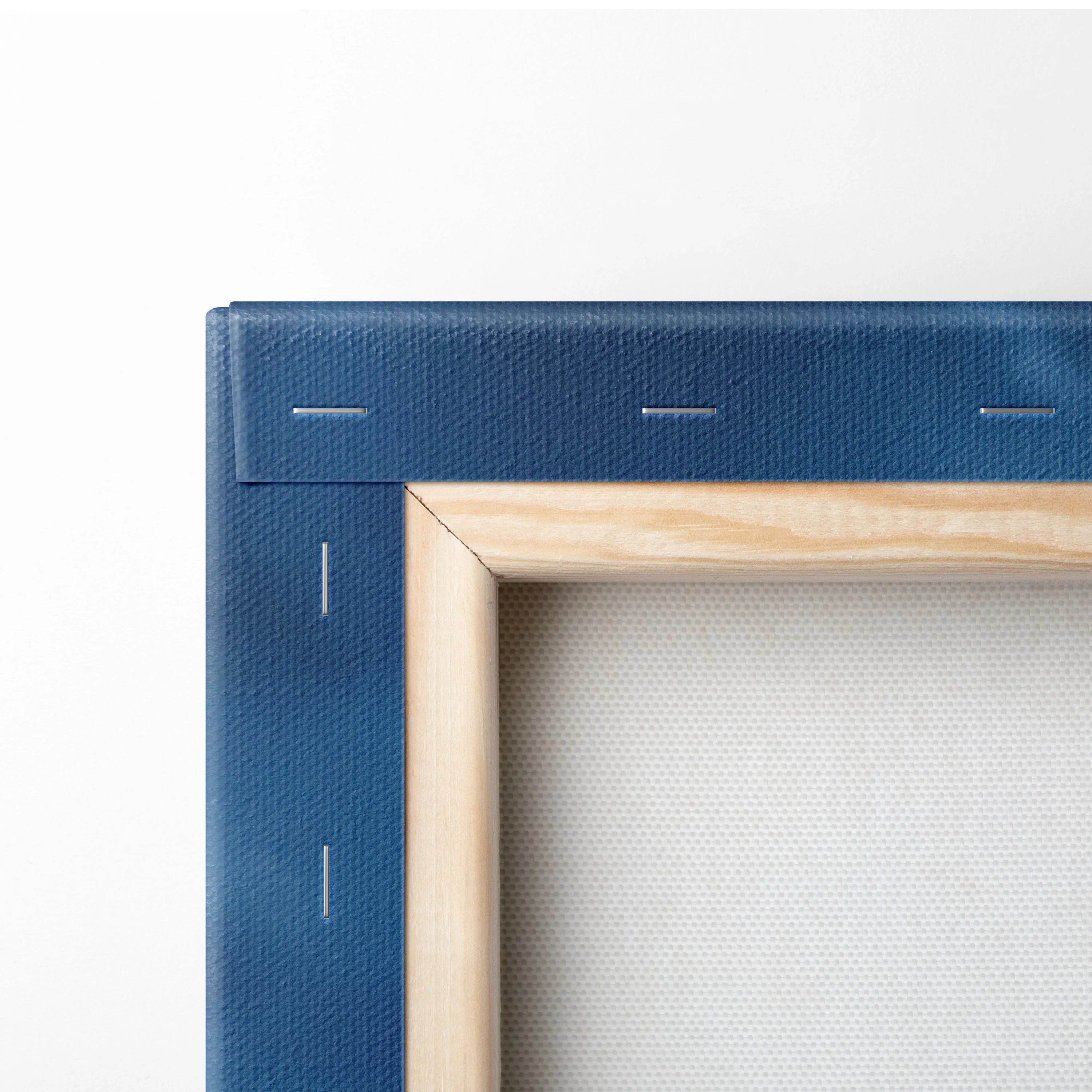 Blue stretched canvas corner with natural wood frame backing and metal staples for wall art.