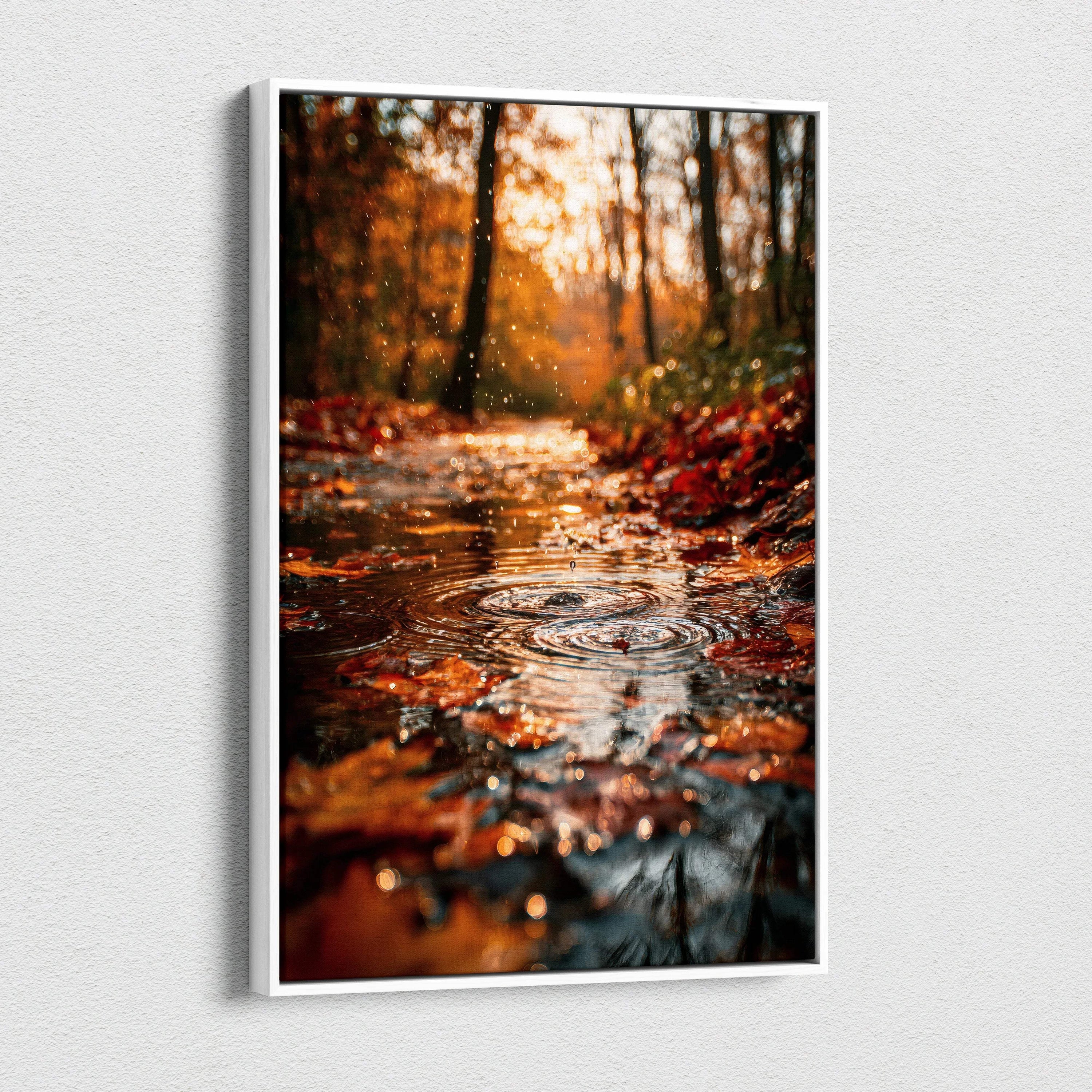Vertical canvas wall art featuring a vibrant autumn forest scene with fallen leaves and a reflective water puddle.