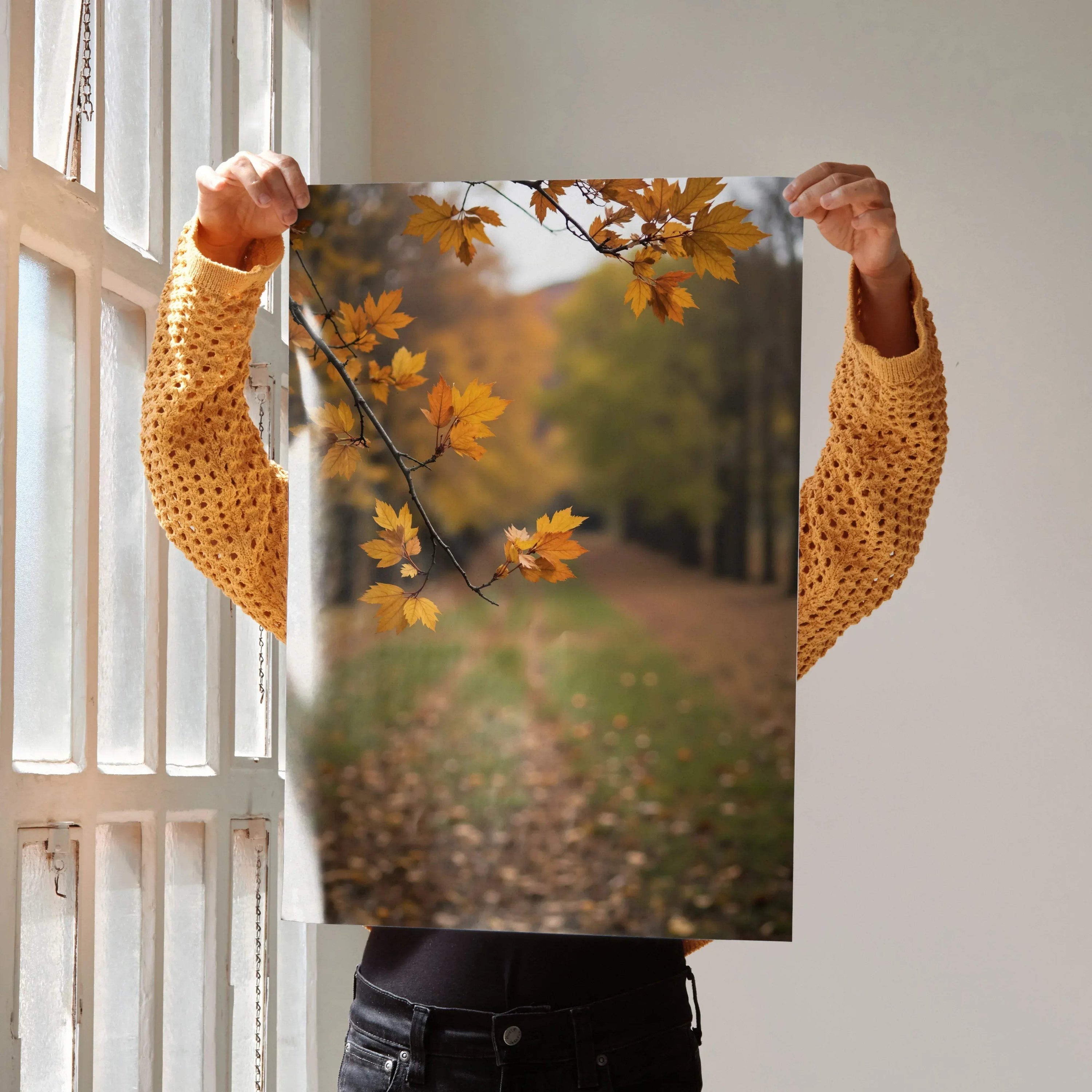 Vibrant autumn leaves on a tree branch over a blurred forest path poster wall art print.