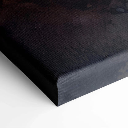 Close-up of dark-toned canvas wall art with textured fabric and wrapped edges.