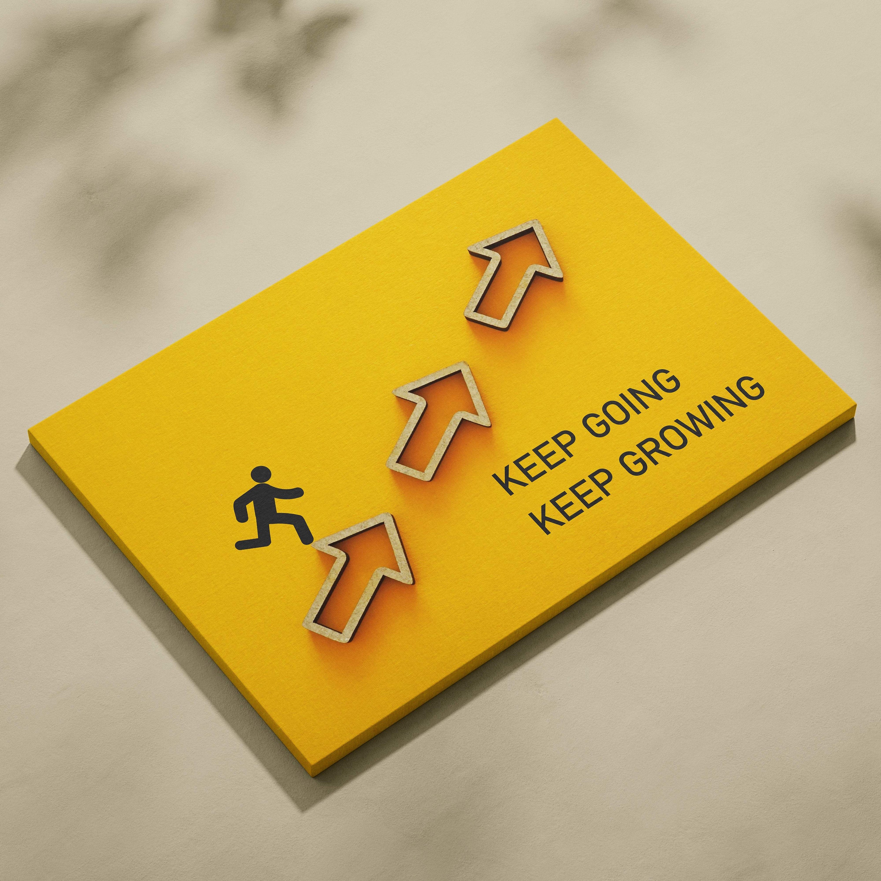 Bright yellow motivational wall art print with raised orange arrows and black running figure saying keep going keep growing