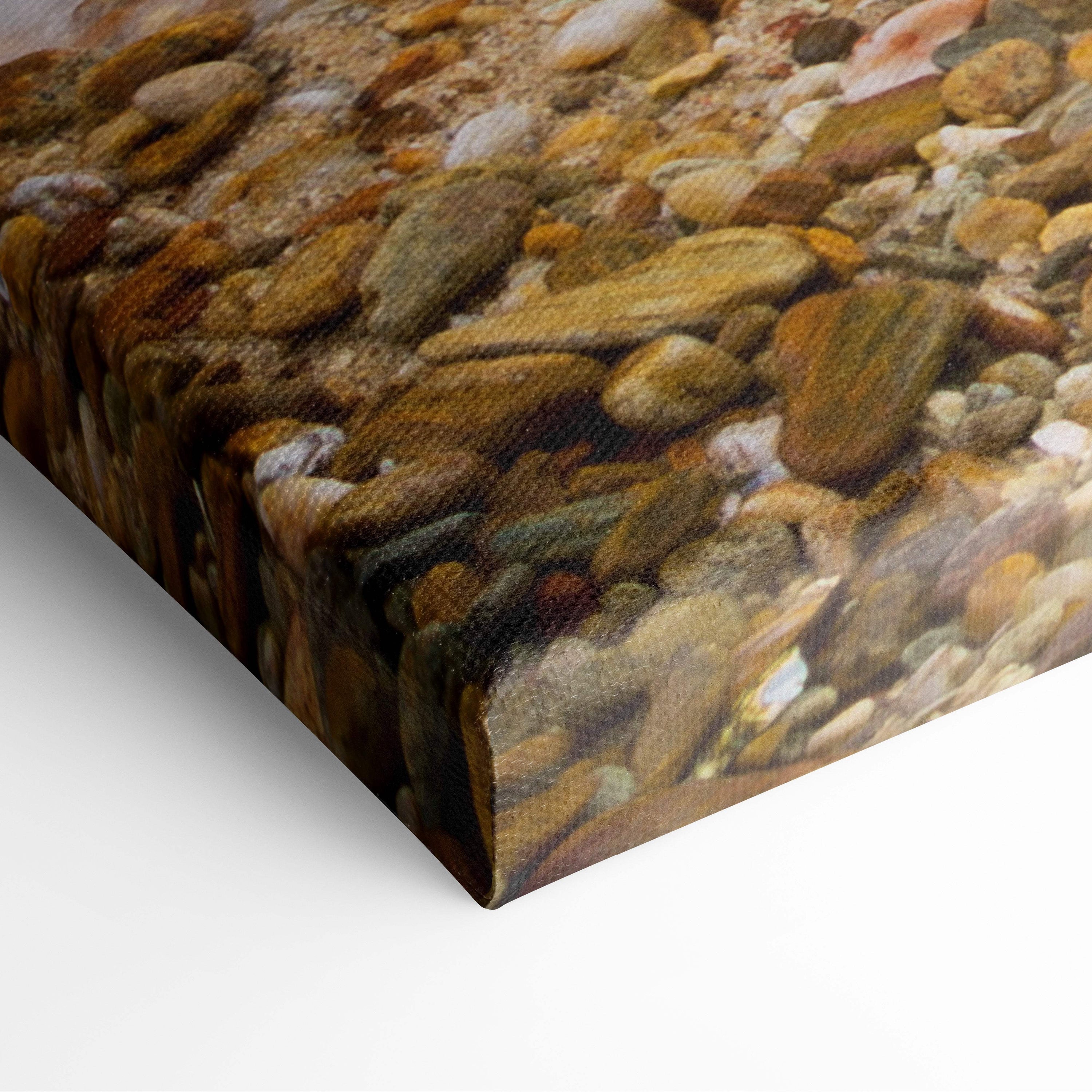 Motivational ocean wave canvas wall art featuring textured smooth river stones in earthy tones for coastal decor