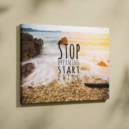 Motivational ocean wave canvas wall art featuring crashing waves rocks and bold stop dreaming start doing text for coastal decor