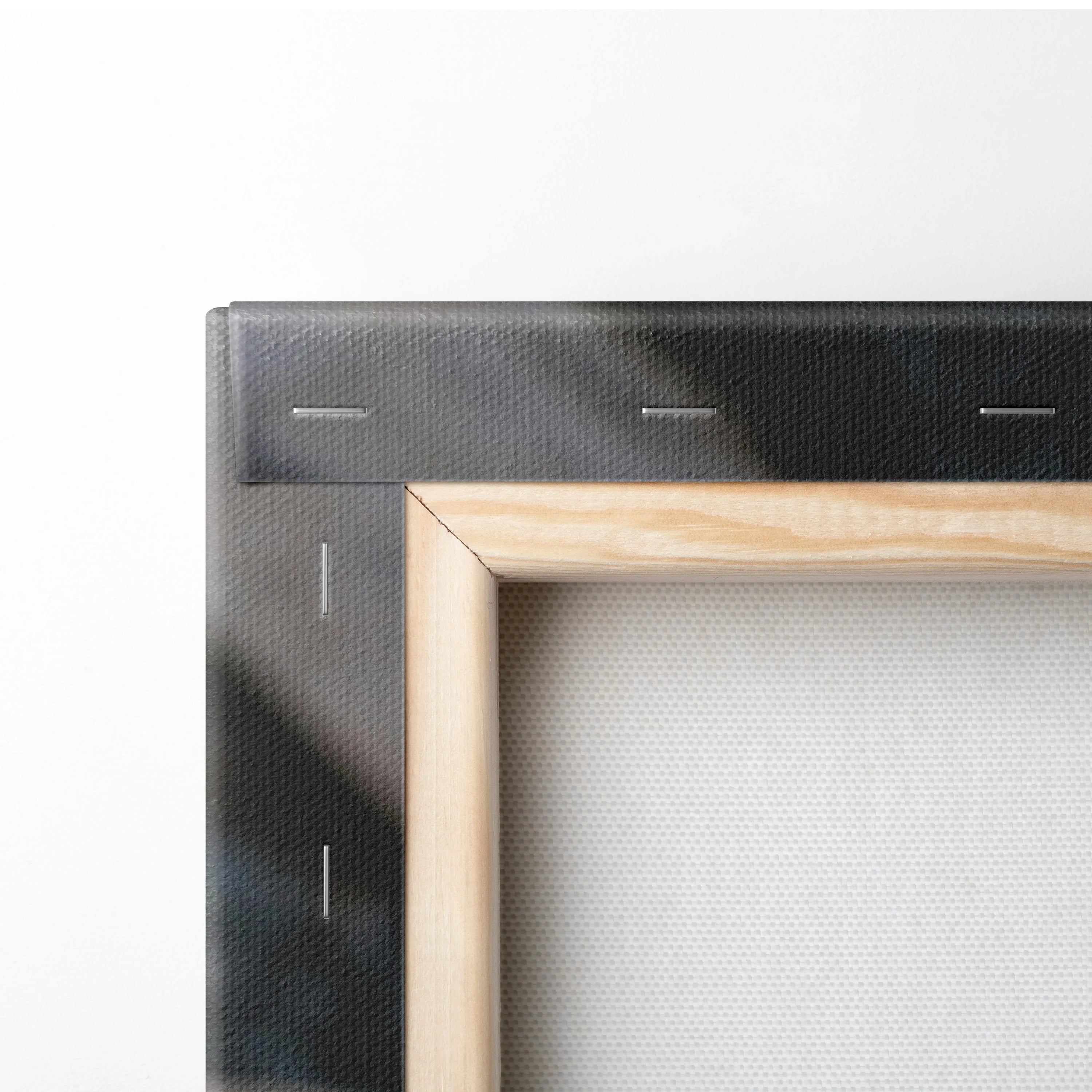 Corner detail of wooden frame stretched with white canvas for wall art display.