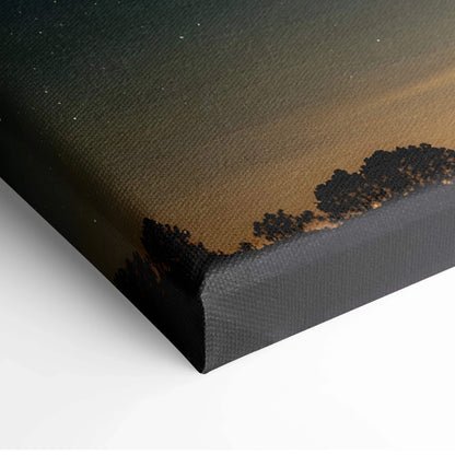 Starry night sky canvas wall art with silhouetted tree line and gradient dark blue to warm brown tones.