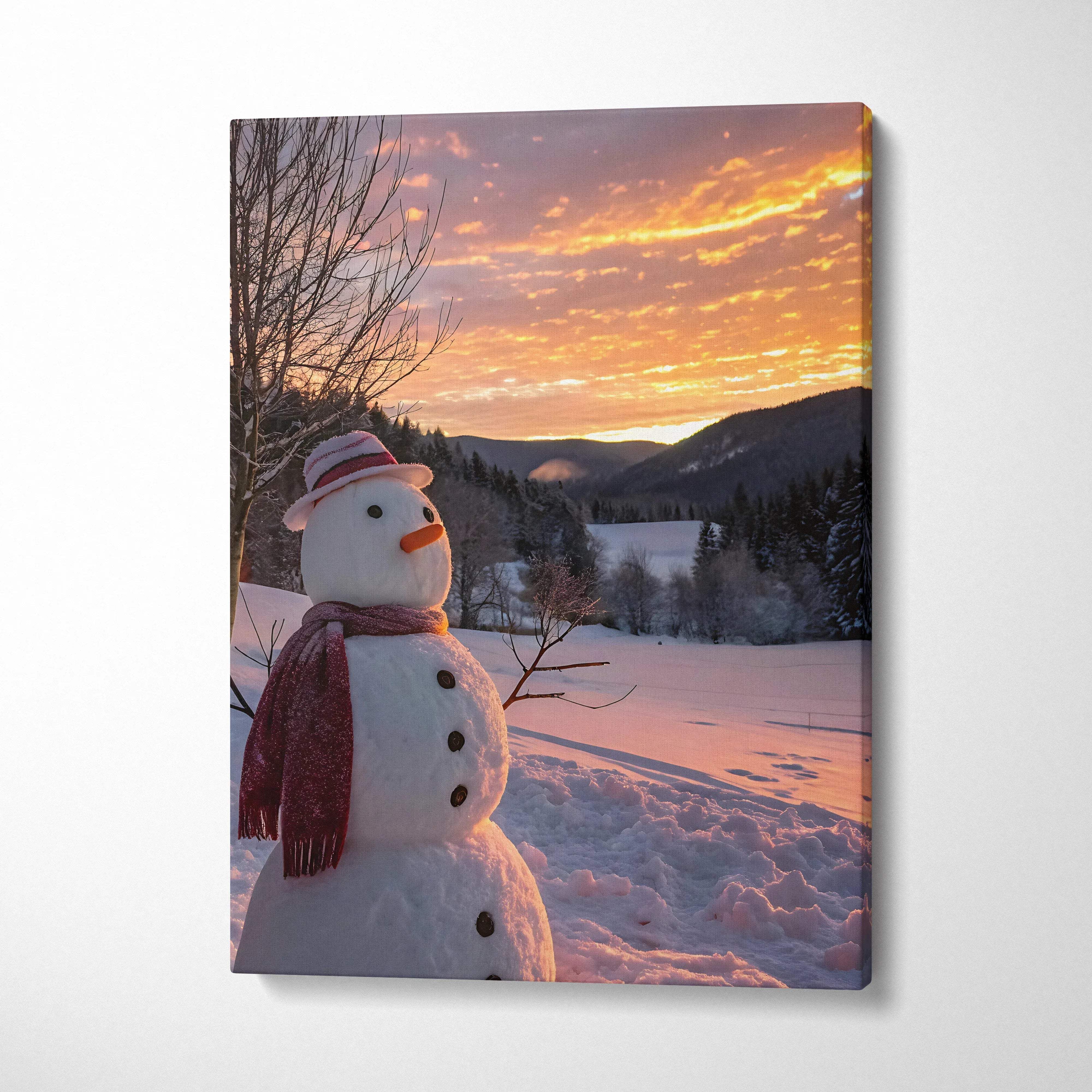 Canvas wall art featuring a snowy landscape with a smiling snowman wearing a red scarf at sunset.