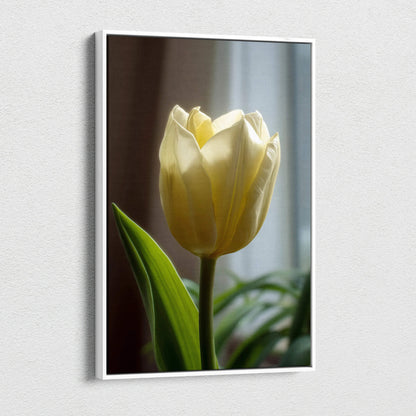 Vertical canvas wall art featuring a close-up of a single pale yellow tulip with green leaves against a blurred background.