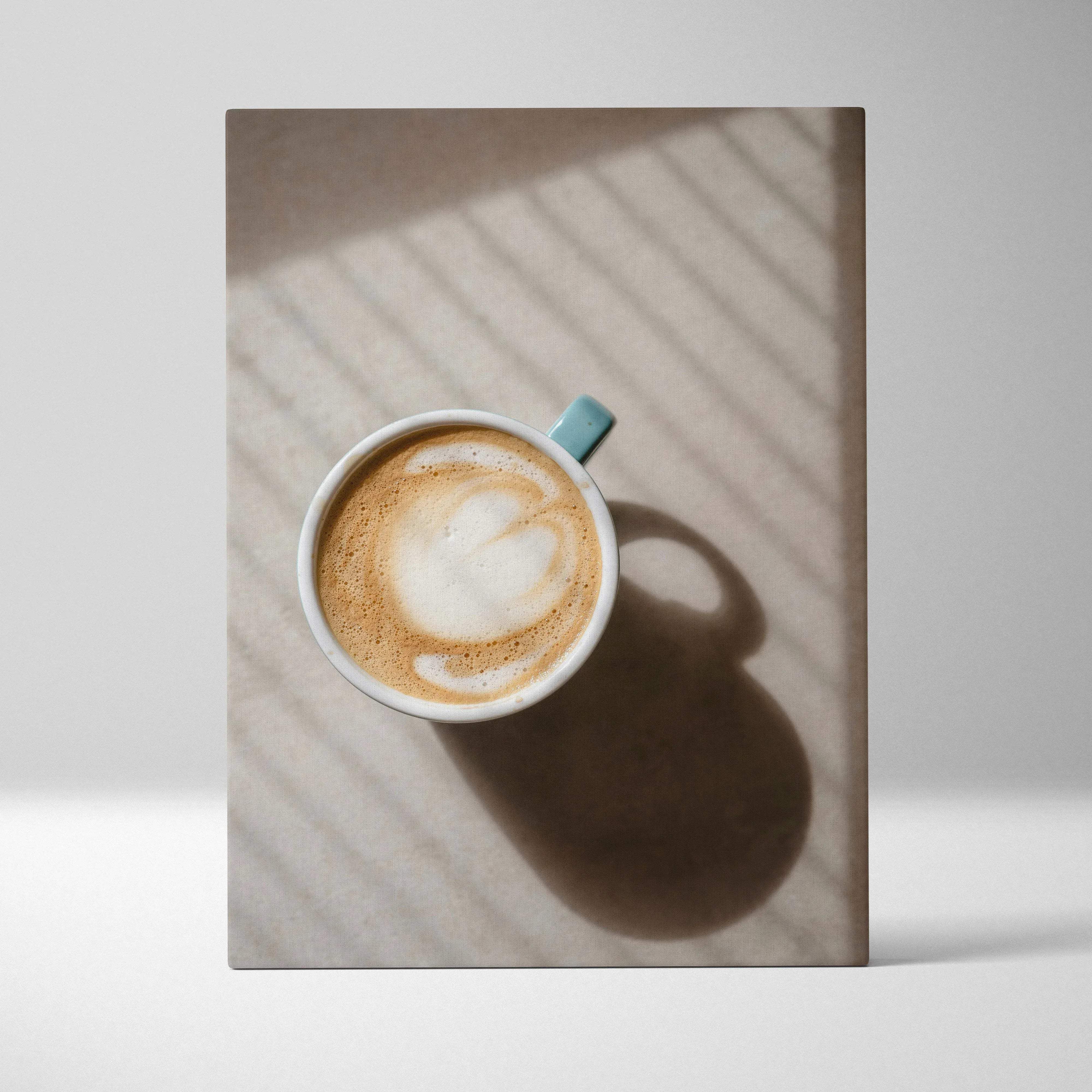 Cozy minimalist ceramic coffee cup wall art with light blue handle and latte art heart in warm neutral tones palette