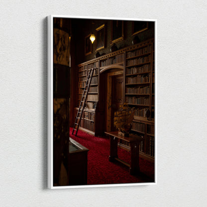 Canvas wall art depicting a dimly lit vintage library with tall bookshelves and a wooden ladder on a red carpeted floor.