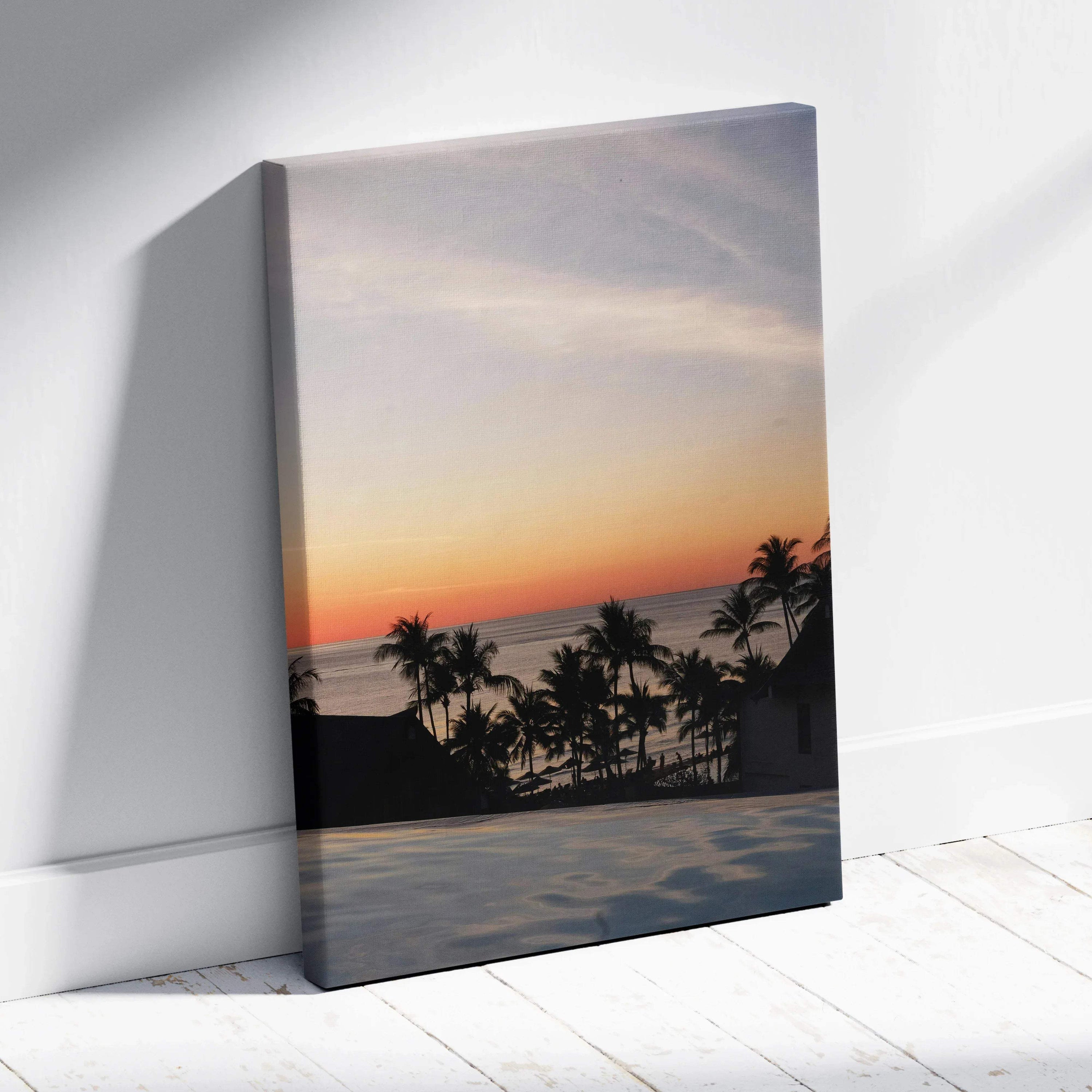Vertical canvas wall art featuring a vivid golden sunset over a palm tree-lined beach with calm ocean waves.