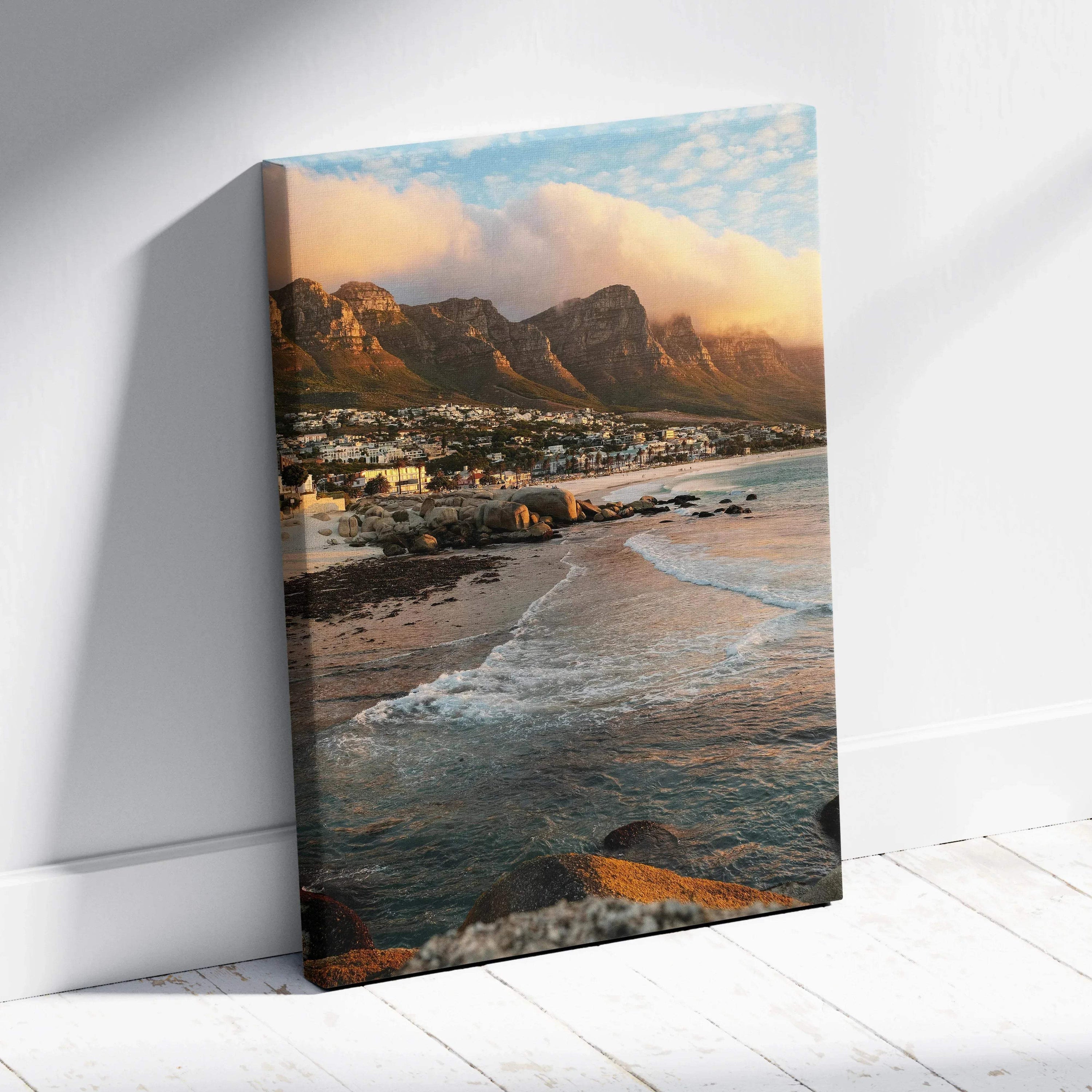Canvas wall art featuring a serene beach with waves and majestic mountains under a cloudy sky.
