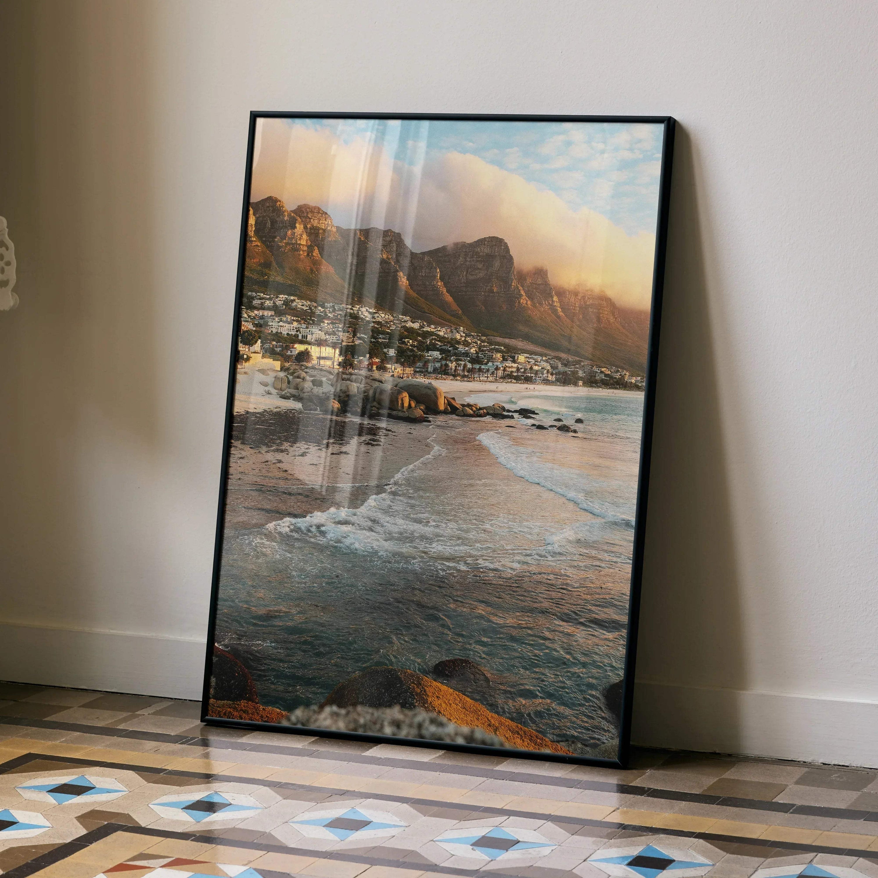 Vertical beach sunset art poster with rocky shoreline and soft pastel sky in black frame.