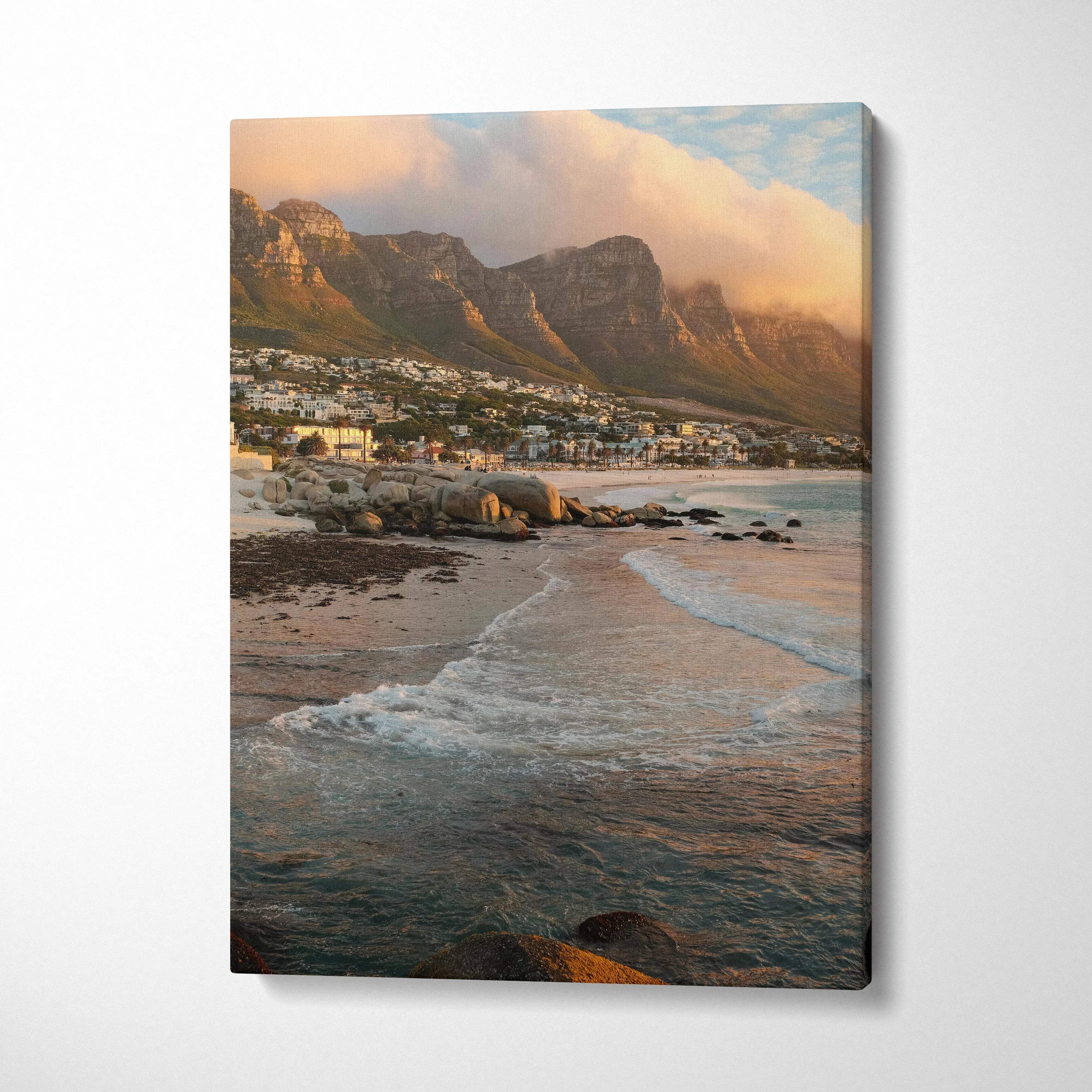 Vertical canvas wall art featuring a serene beach with gentle waves and majestic mountain backdrop at sunset.