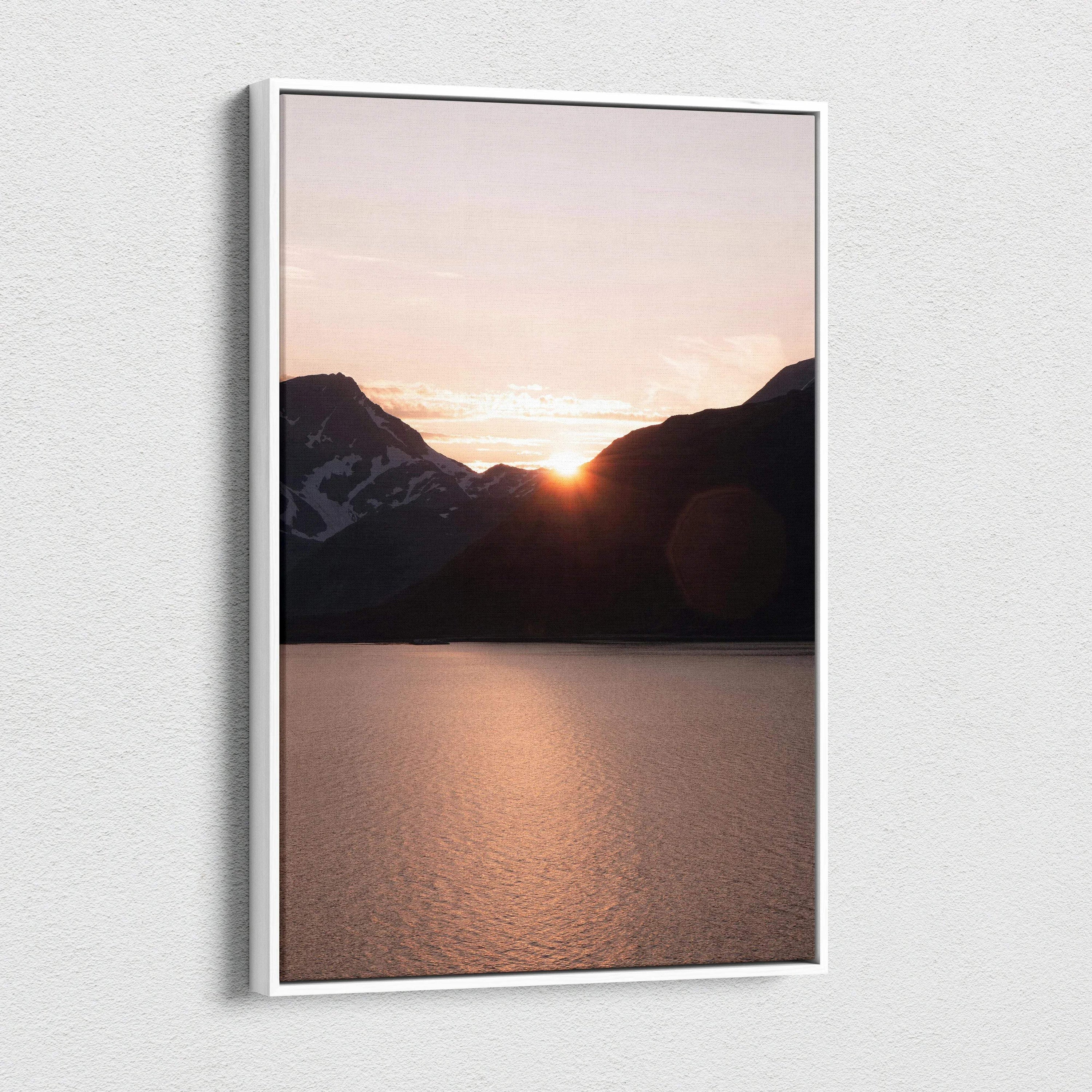 Canvas wall art featuring a mountain sunset with glowing orange sky over a calm lake.