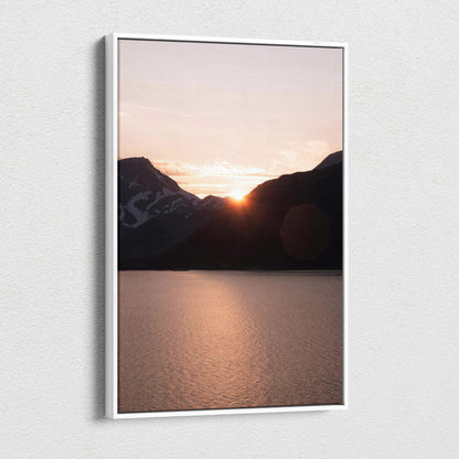 Canvas wall art featuring a mountain sunset with glowing orange sky over a calm lake.