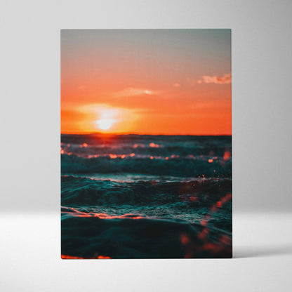 Ocean sunset over waves with vibrant orange and teal hues on canvas wall art.
